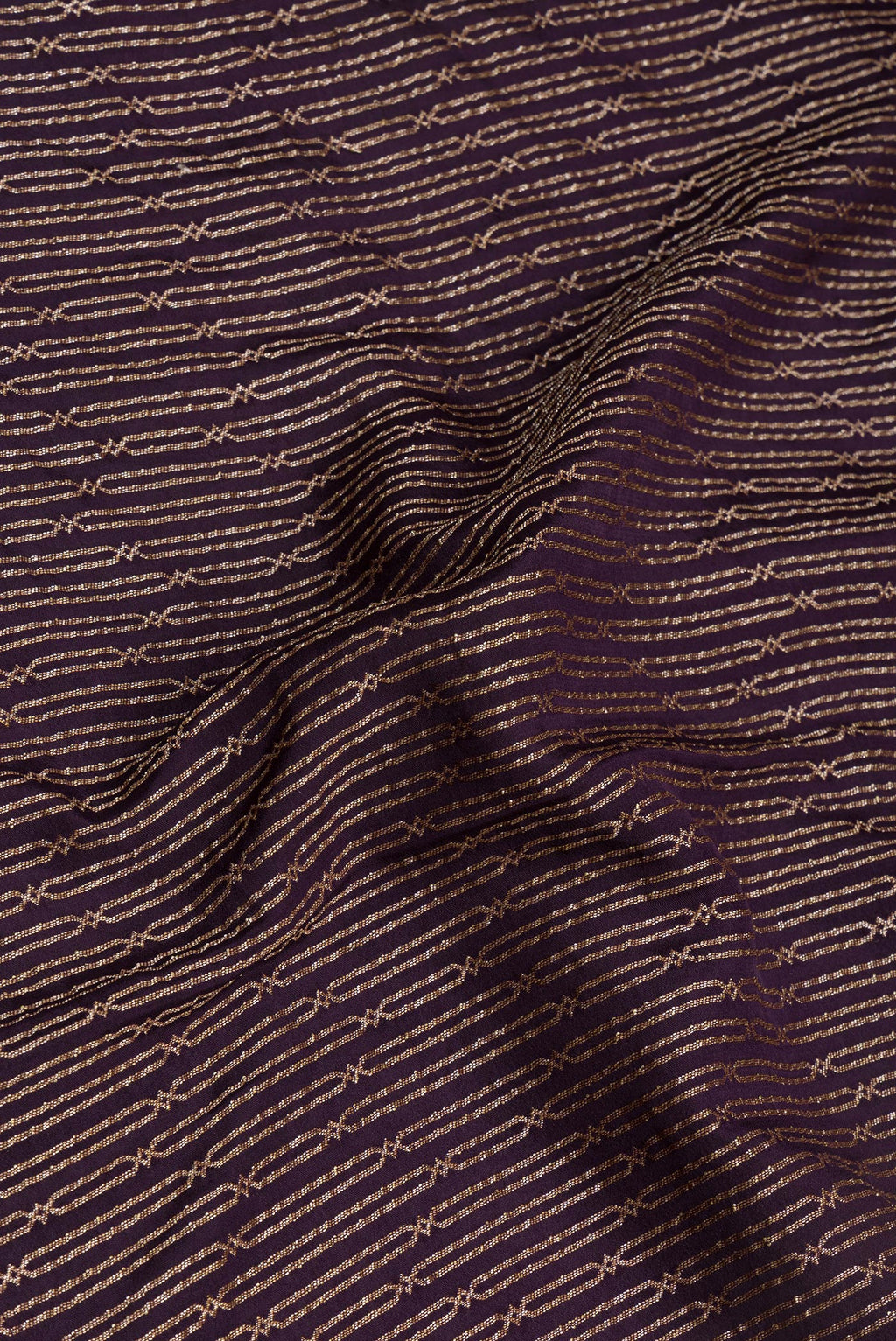 Close up of Burgundy Banarasi Georgette Saree with Zari Brocade on the body and Fancy Border.  displaying folds