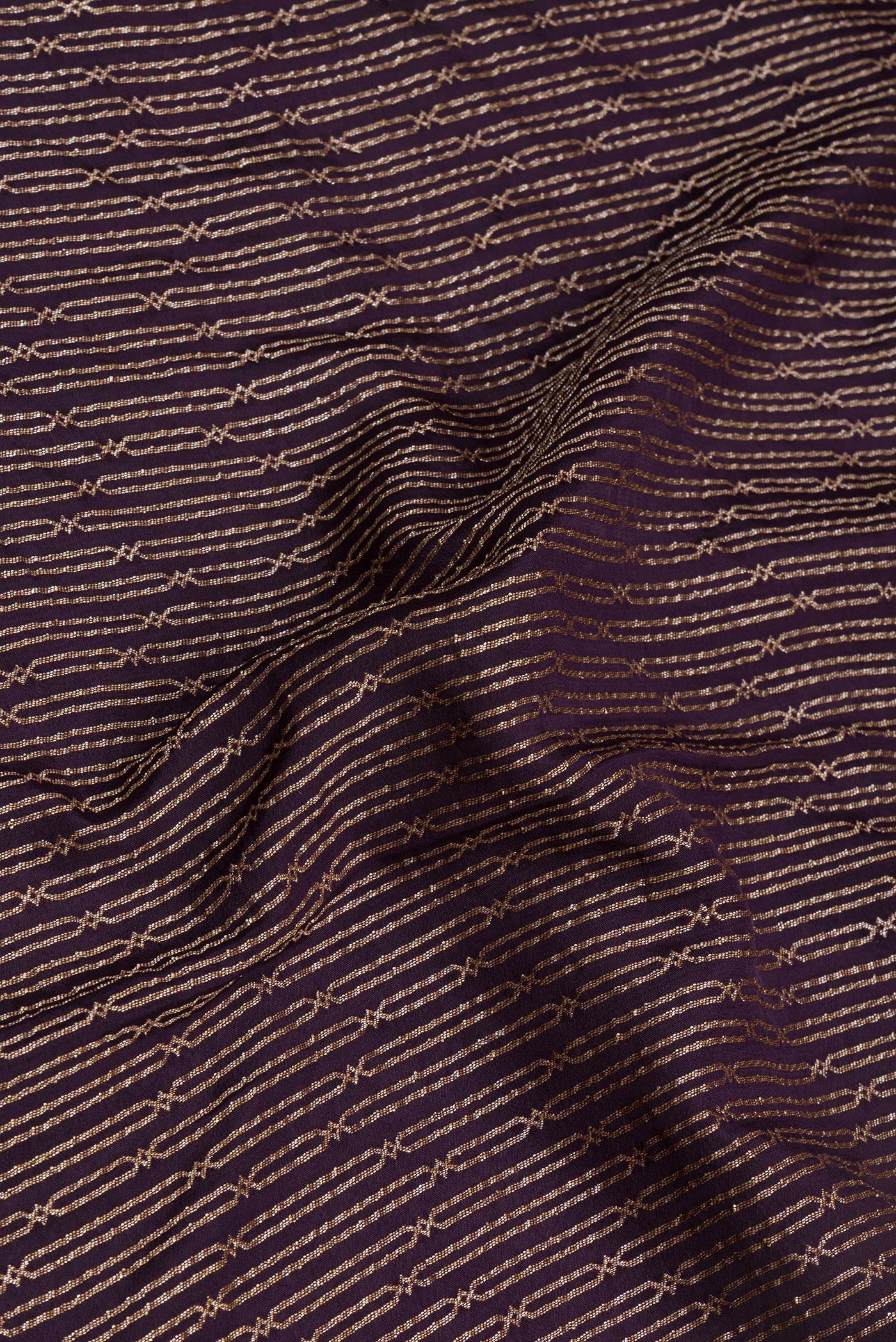 Close up of Burgundy Banarasi Georgette Saree with Zari Brocade on the body and Fancy Border.  displaying folds