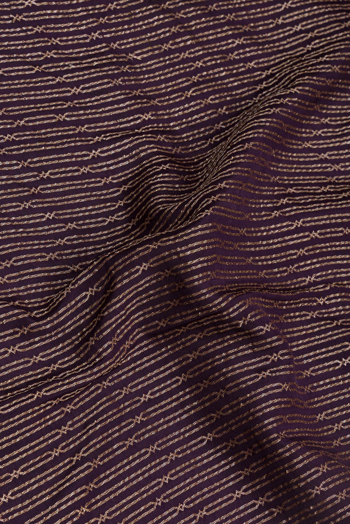 Close up of Burgundy Banarasi Georgette Saree with Zari Brocade on the body and Fancy Border.  displaying folds