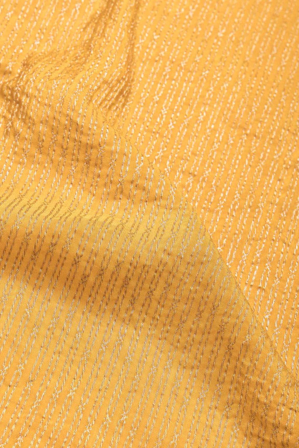 Close up of Mustard Dual Tone Banarasi Georgette Saree with Zari Brocade on the body and Zari Border.  displaying folds