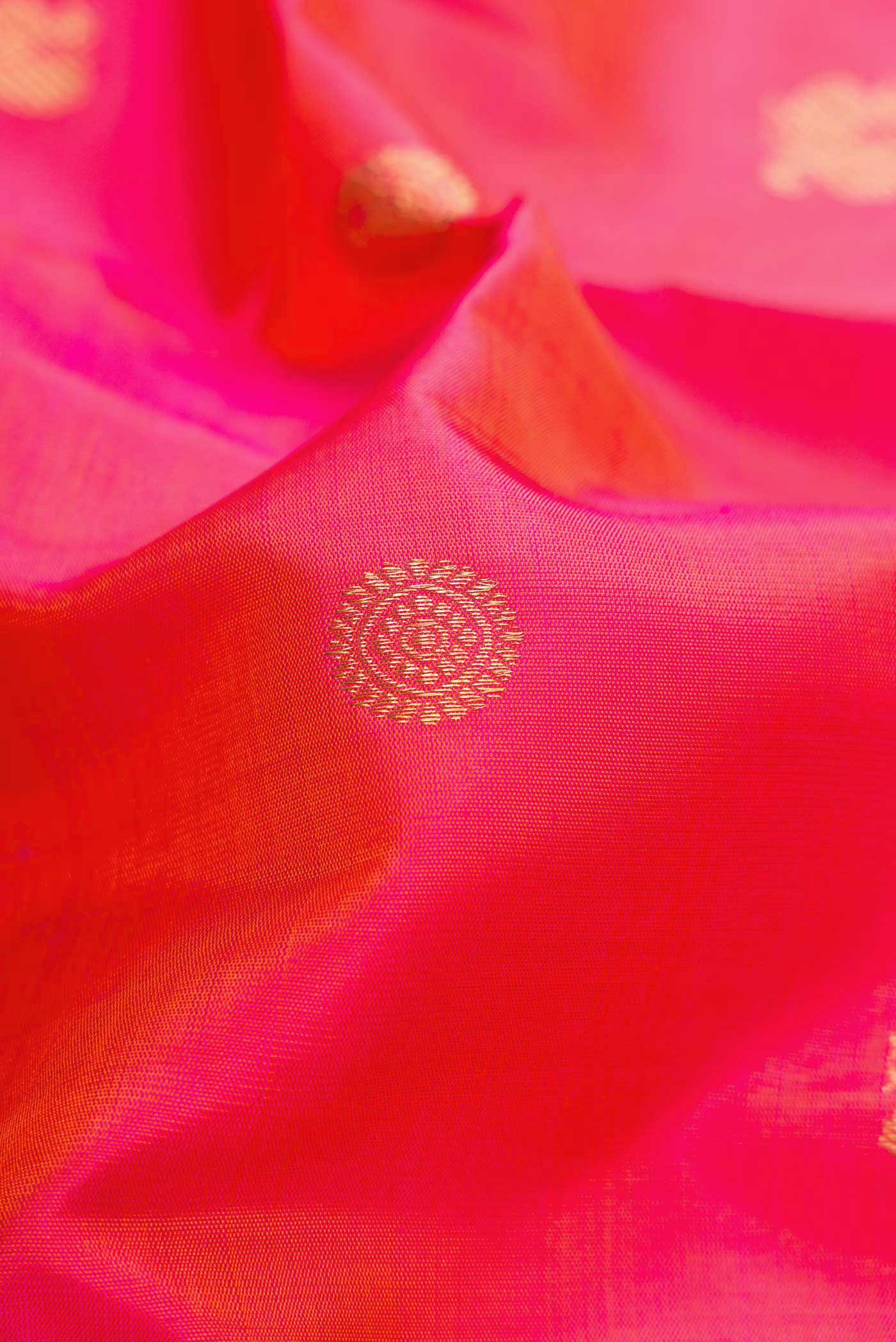 Close up of Coral Dual Tone Kanchipuram Silk Saree with Zari Butta on the body and Zari Border.  displaying folds