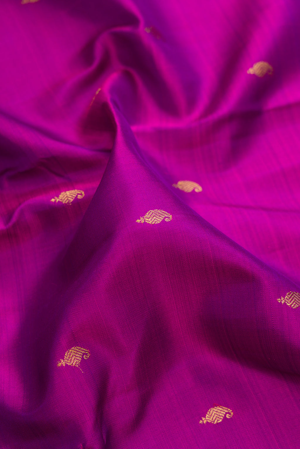 Close up of Pure Silk Pure Zari Purple Kanchipuram Saree with Zari Butta on the body and Zari Border.  displaying folds
