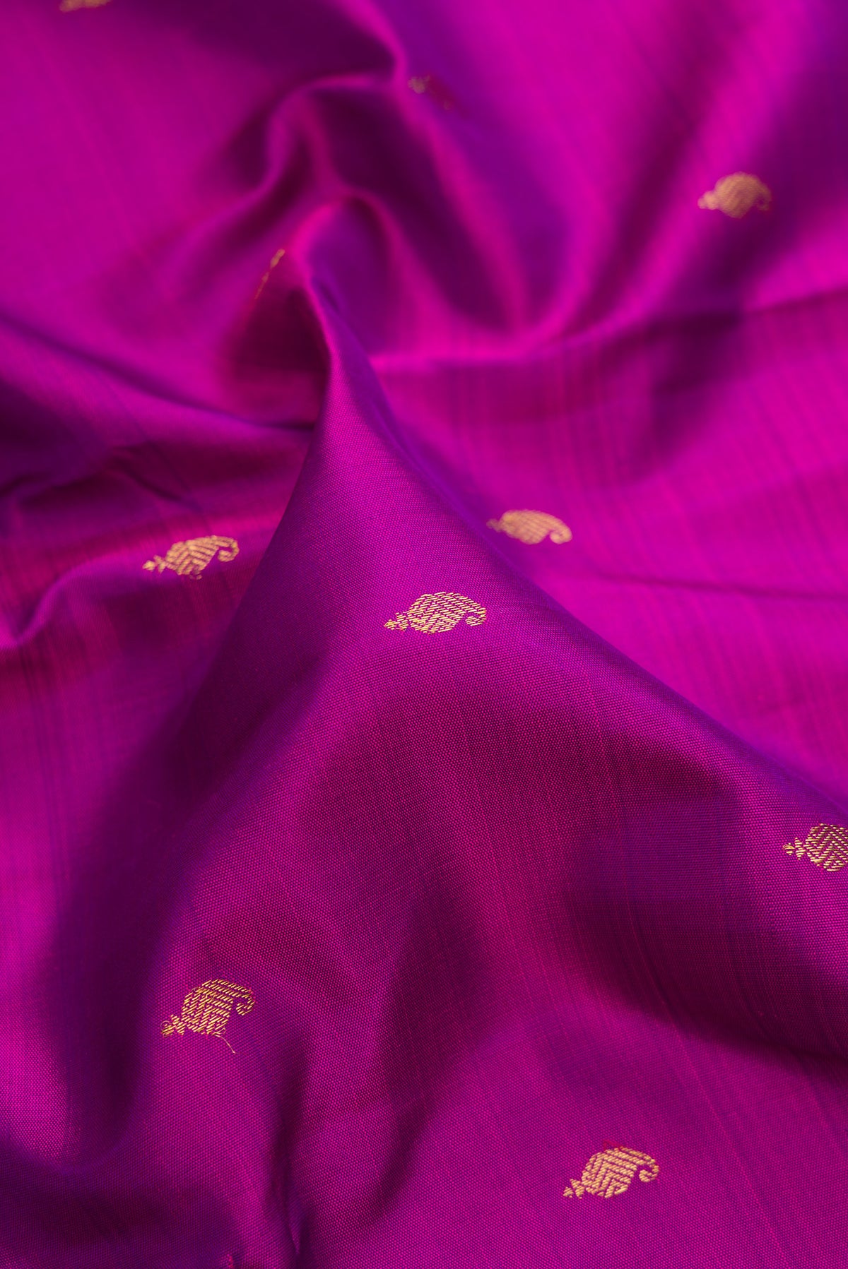 Close up of Pure Silk Pure Zari Purple Kanchipuram Saree with Zari Butta on the body and Zari Border.  displaying folds