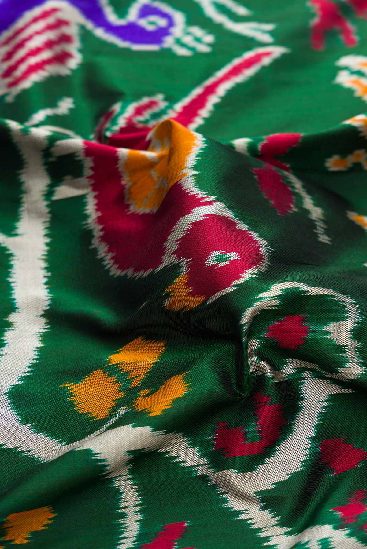 Close up of Pure Silk Pure Zari Green Dual Tone Double Ikat Saree with Zari Brocade on the body and Paithani Border displaying folds