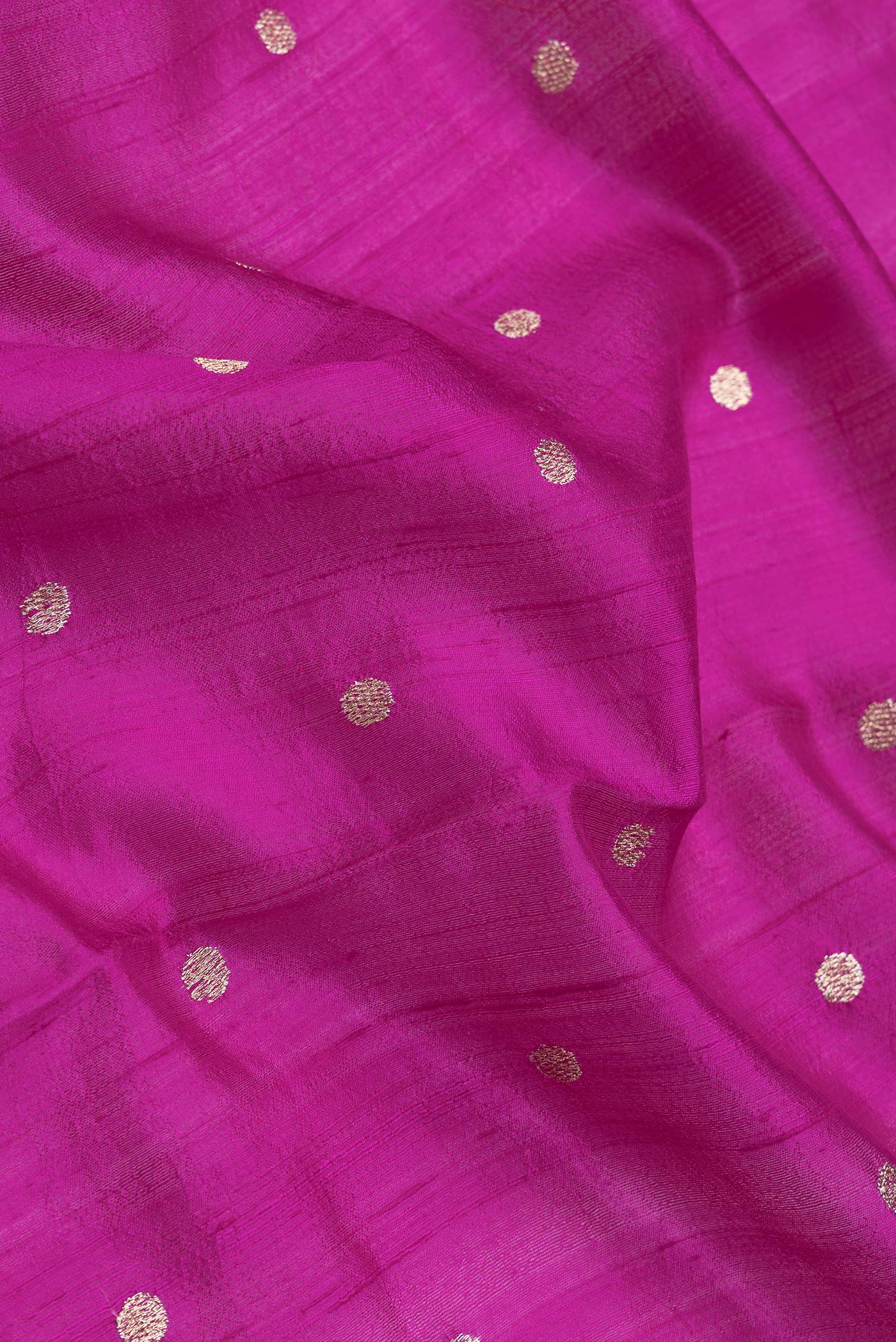 Close up of Magenta Dual Tone Tussar Silk Saree with Zari Butta on the body and Embroidery Border.  displaying folds