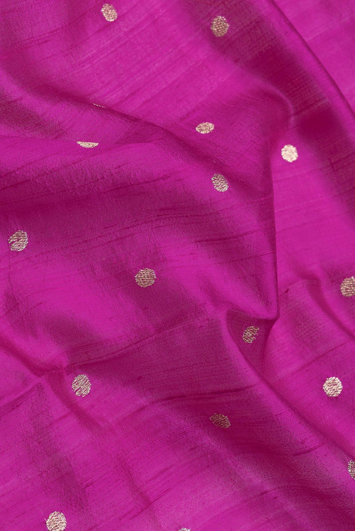 Close up of Magenta Dual Tone Tussar Silk Saree with Zari Butta on the body and Embroidery Border.  displaying folds