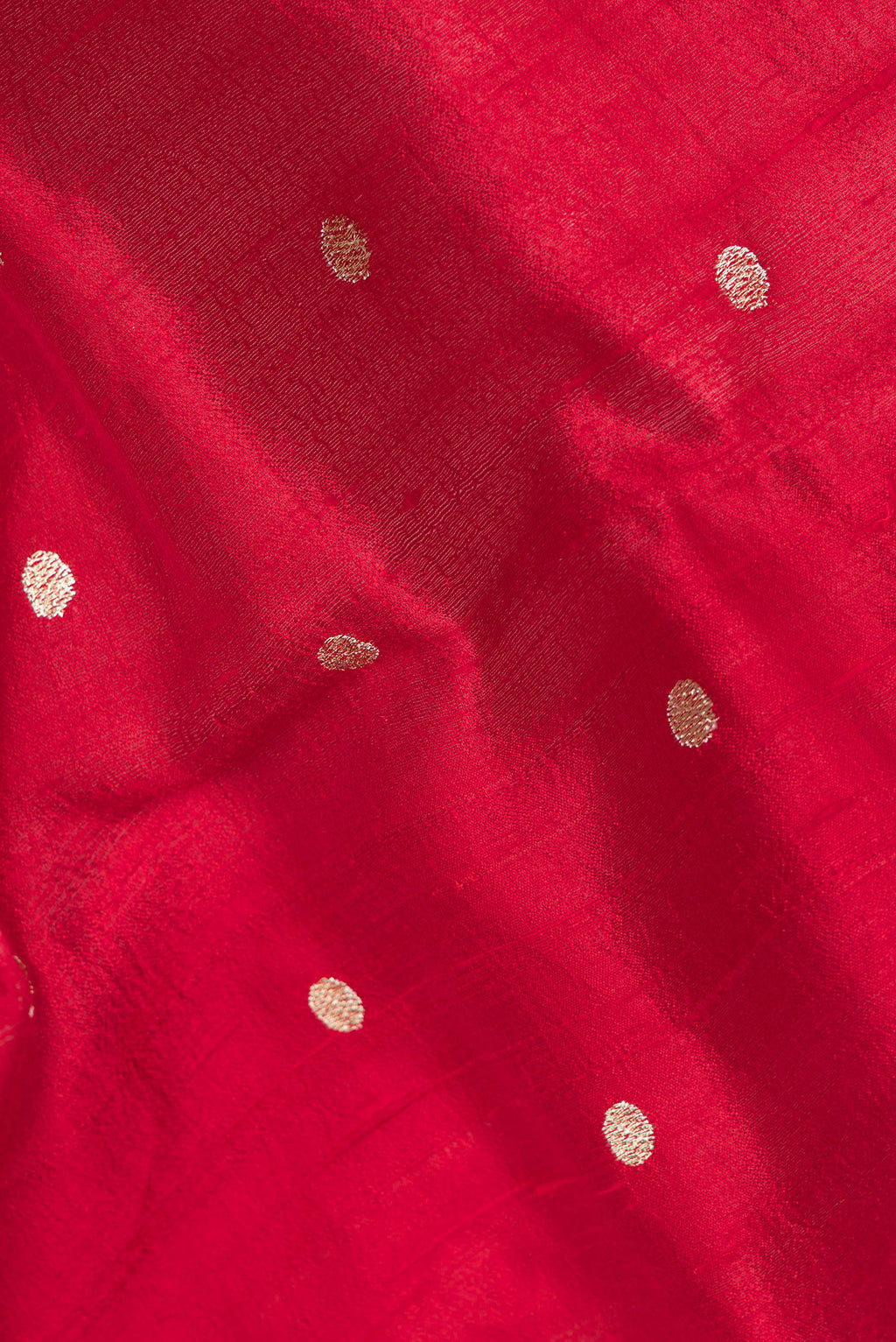 Close up of Pure Silk Red Tussar Saree with Zari Butta on the body and Embroidery Border.  displaying folds