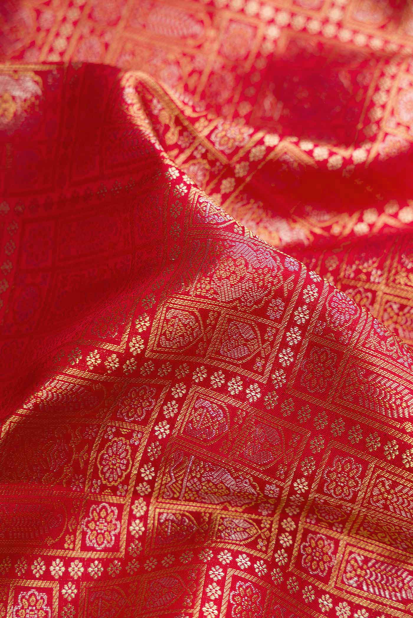 Close up of Red Dual Tone Kanchipuram Silk Saree with Zari Brocade on the body and Zari Border.  displaying folds