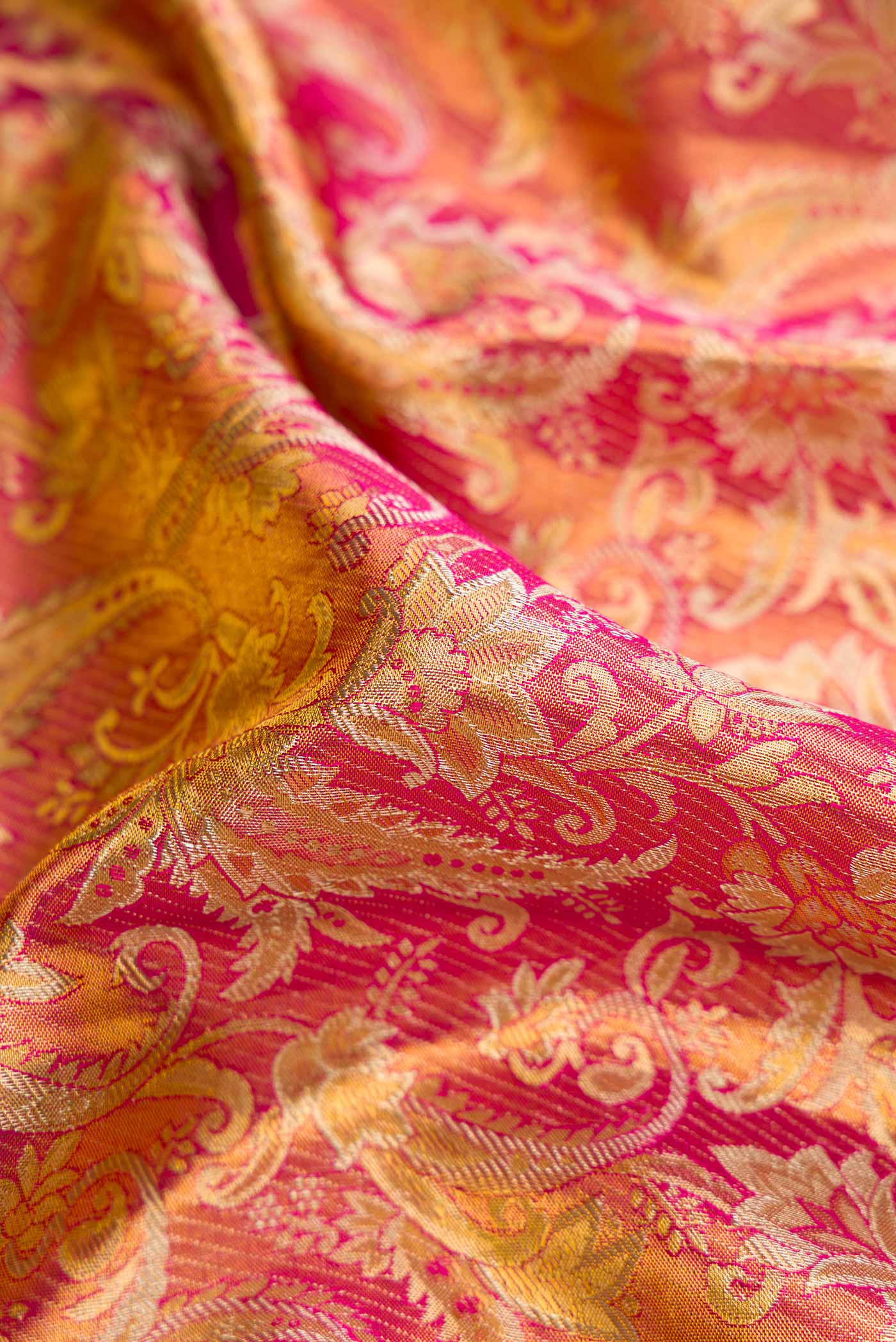 Close up of Dark Pink Dual Tone Kanchipuram Tissue Silk Saree with Zari Brocade on the body and Zari Border.  displaying folds