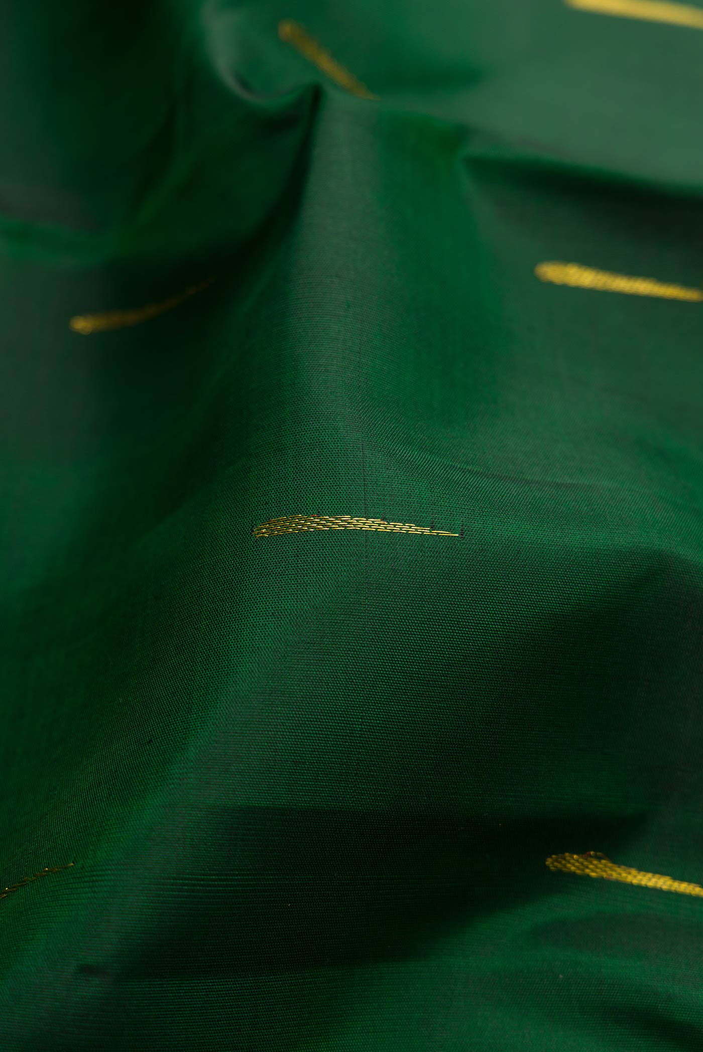 Close up of Bottle Green Dual Tone Kanchipuram Silk Saree with Zari Butta on the body and Zari Border.  displaying folds