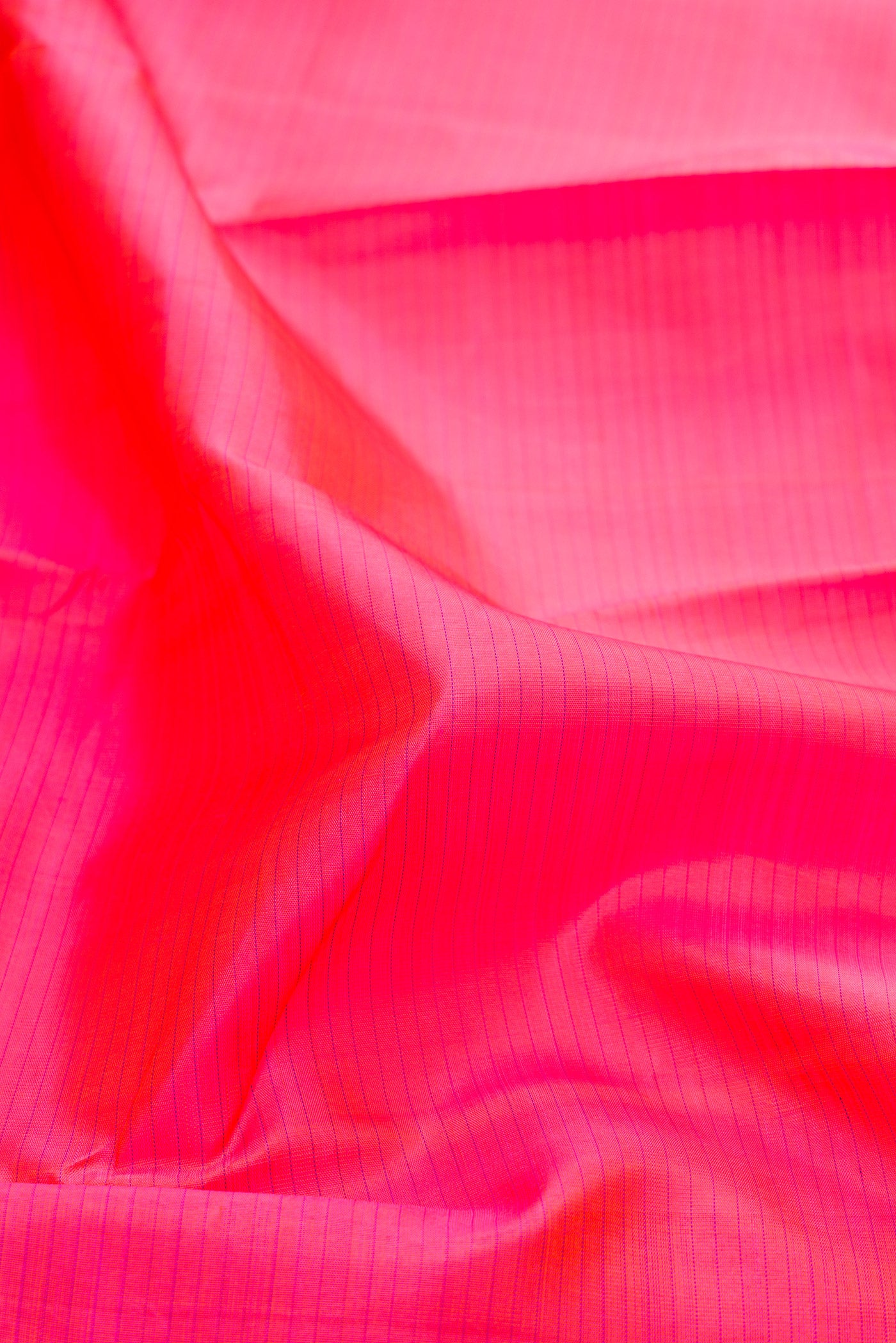 Close up of Pink Kanjivaram Silk Saree with Stripes on the body and Zari Border.  displaying folds