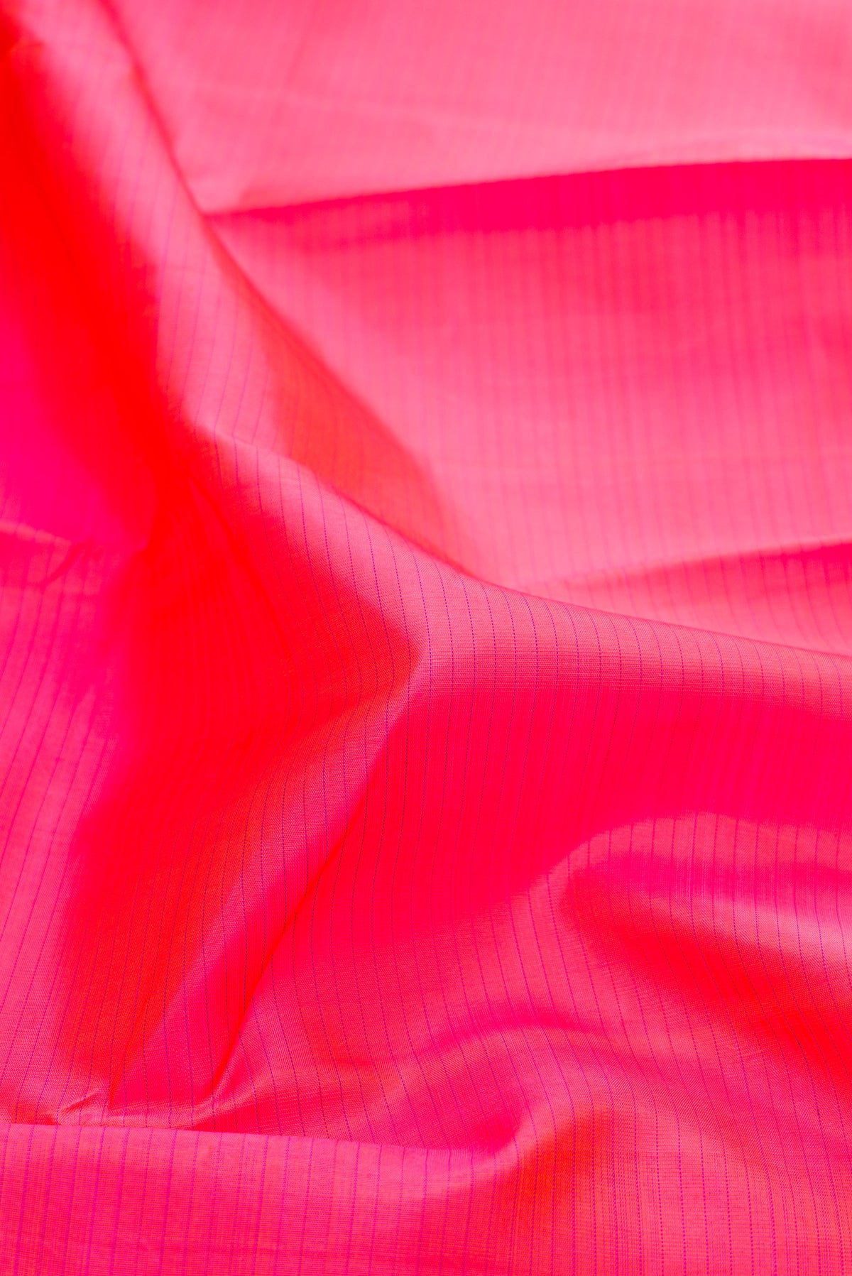 Close up of Pink Kanjivaram Silk Saree with Stripes on the body and Zari Border.  displaying folds