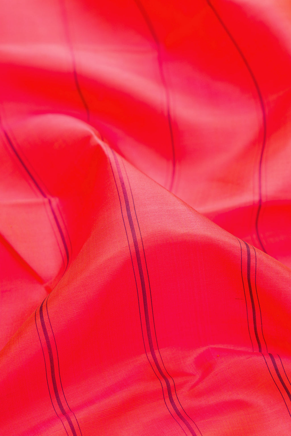 Close up of Coral Dual Tone Kanjivaram Silk Saree with Stripes on the body and Ganga Jamuna Border.  displaying folds