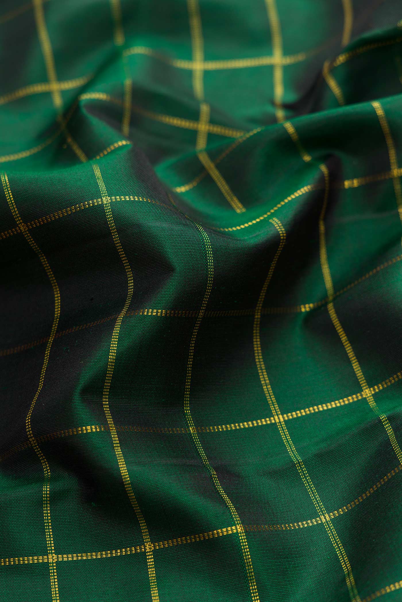 Close up of Pure Silk Pure Zari Green Dual Tone Kanchipuram Saree with Checked design on the body and Checks Border displaying folds