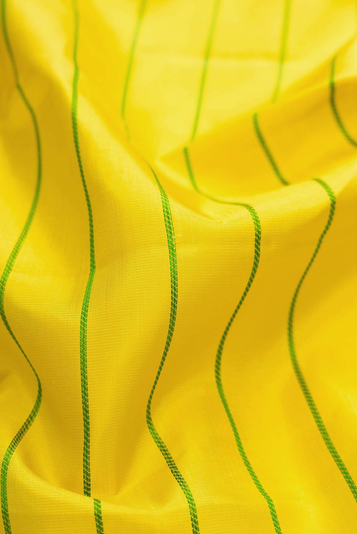 Close up of Yellow Dual Tone Kanchipuram Silk Saree with Stripes on the body and Zari Border displaying folds