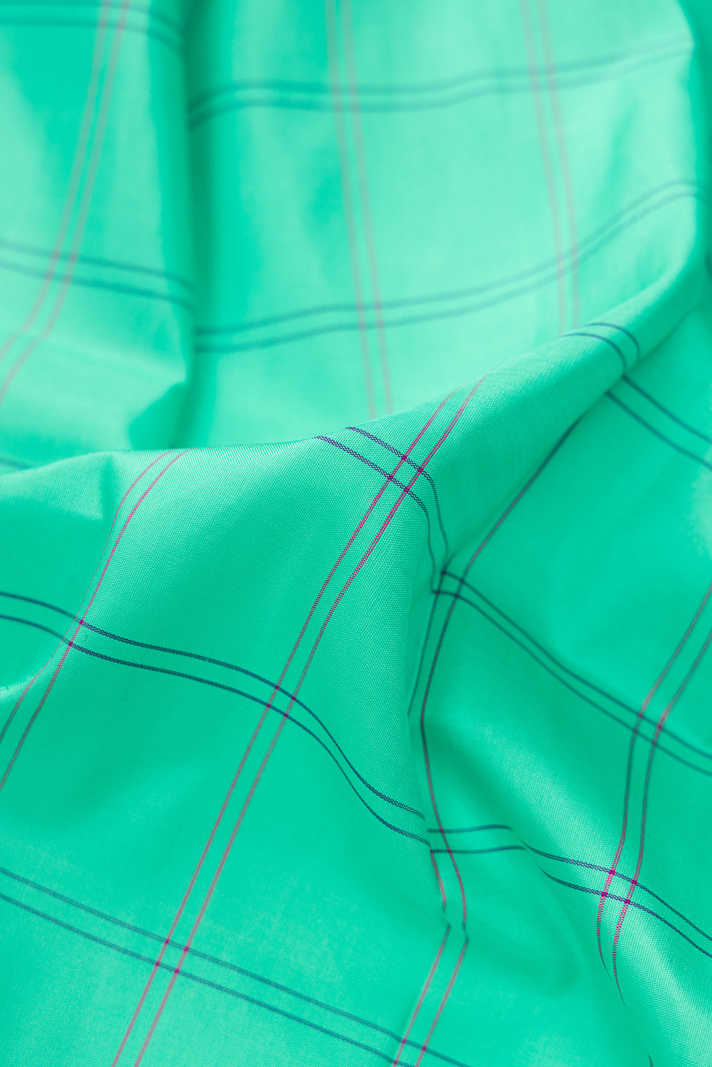 Close up of Pure Silk Pure Zari Sea Green Dual Tone Kanjivaram Saree with Checked design on the body and Zari And Thread Border.  displaying folds