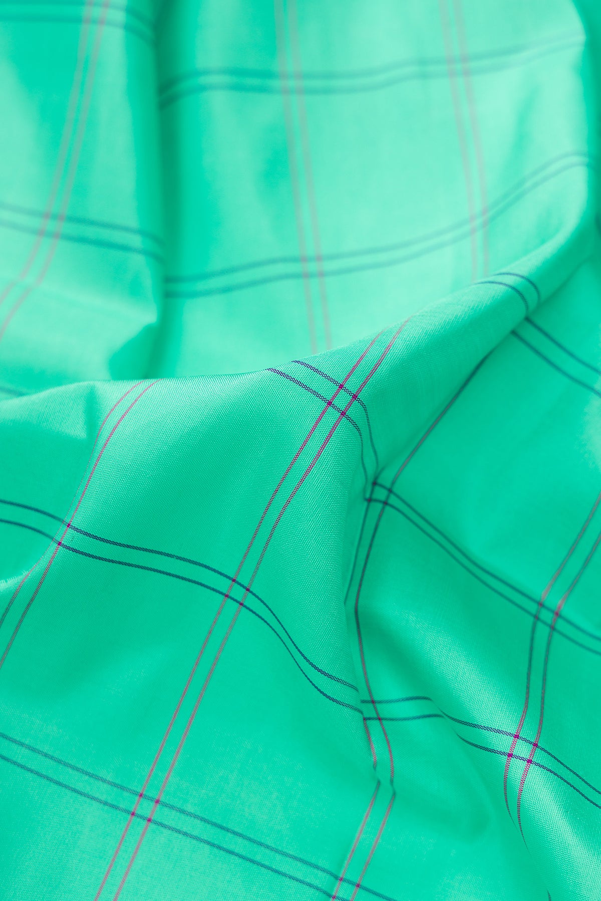 Close up of Pure Silk Pure Zari Sea Green Dual Tone Kanjivaram Saree with Checked design on the body and Zari And Thread Border.  displaying folds