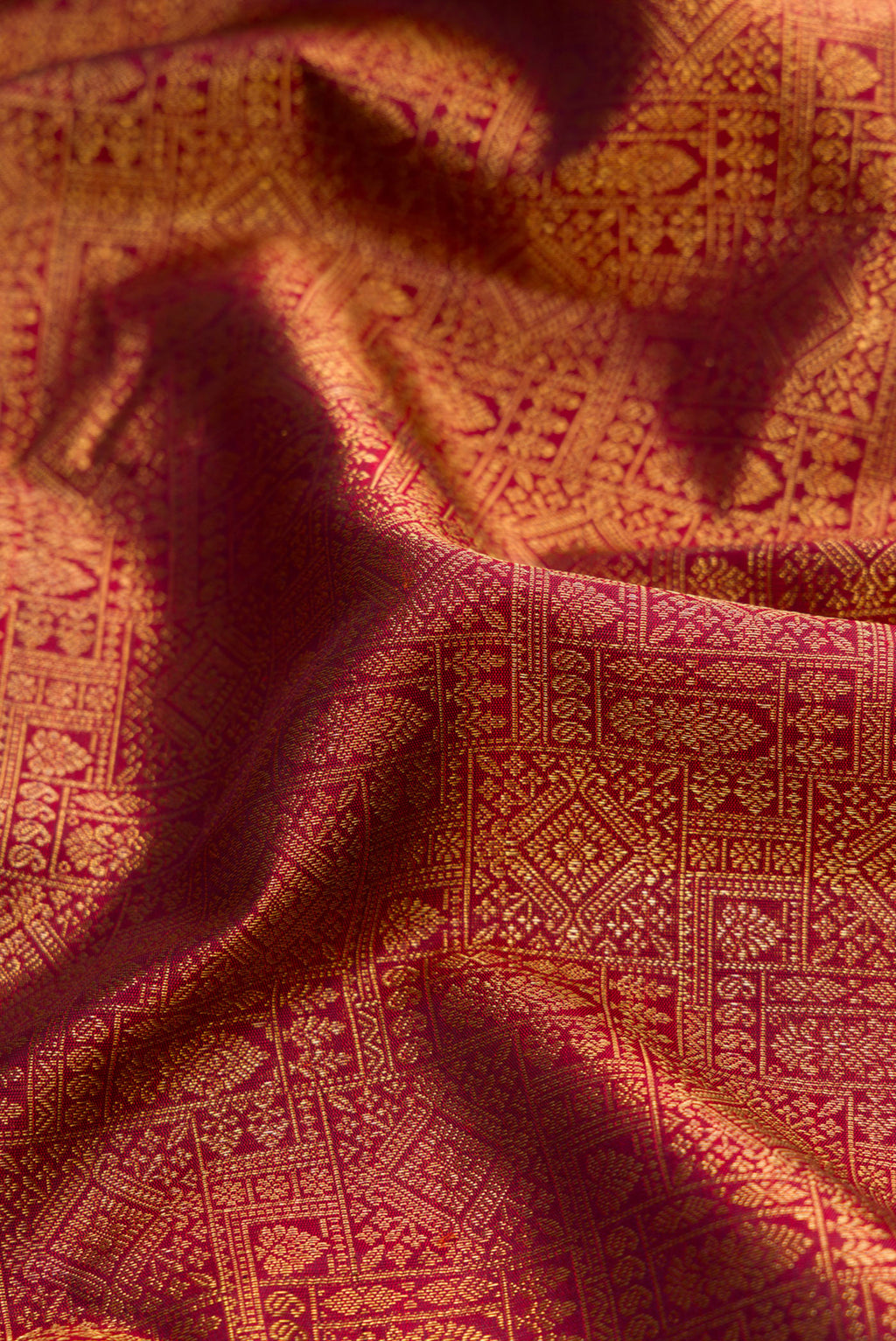 Close up of Pure Silk Pure Zari Maroon Dual Tone Kanjivaram Saree with Zari Brocade on the body and Zari Border.  displaying folds