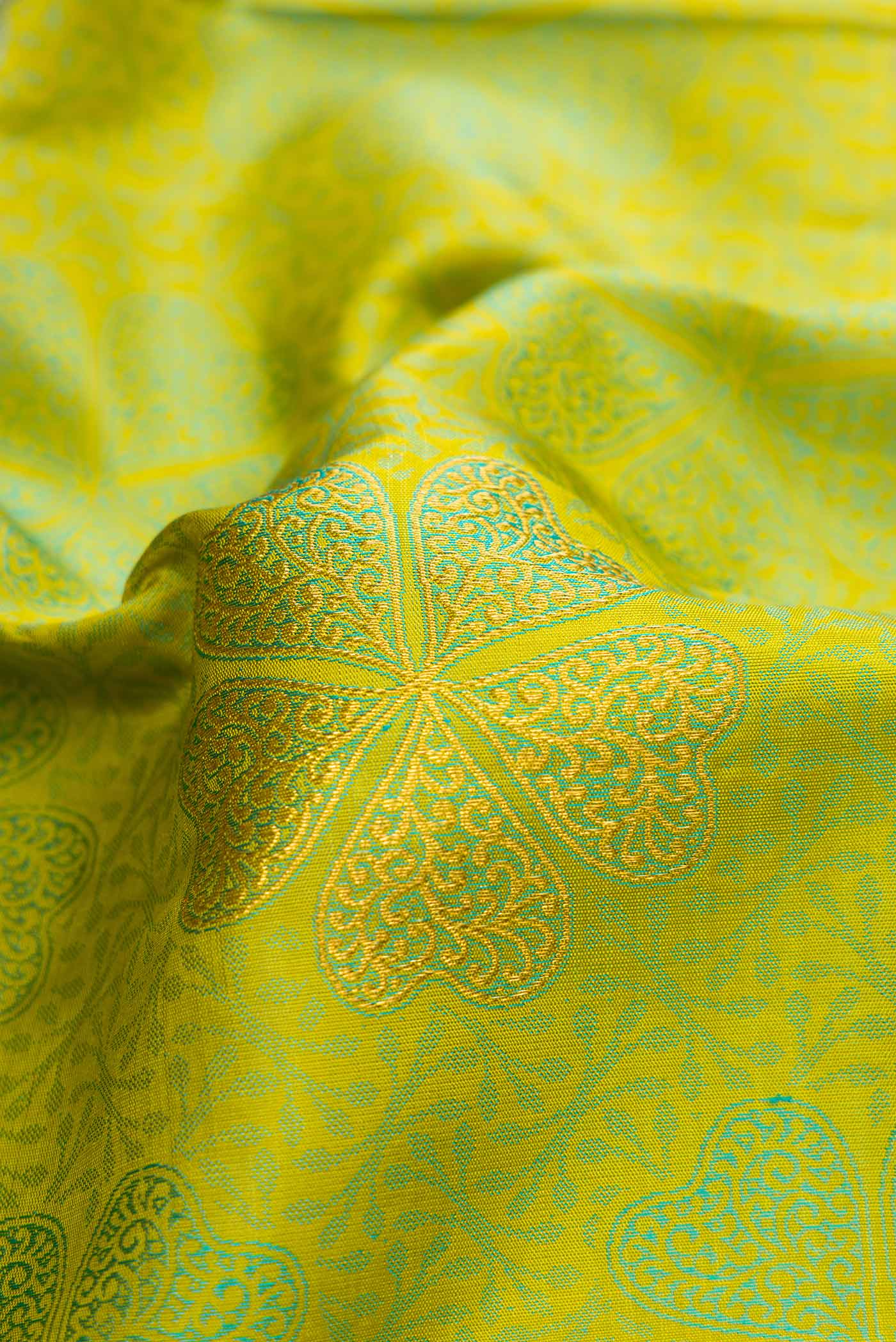 Close up of Pure Silk Pure Zari Parrot Green Dual Tone Kanchipuram Saree with Jacquard With Zari Butta on the body and Zari Border.  displaying folds