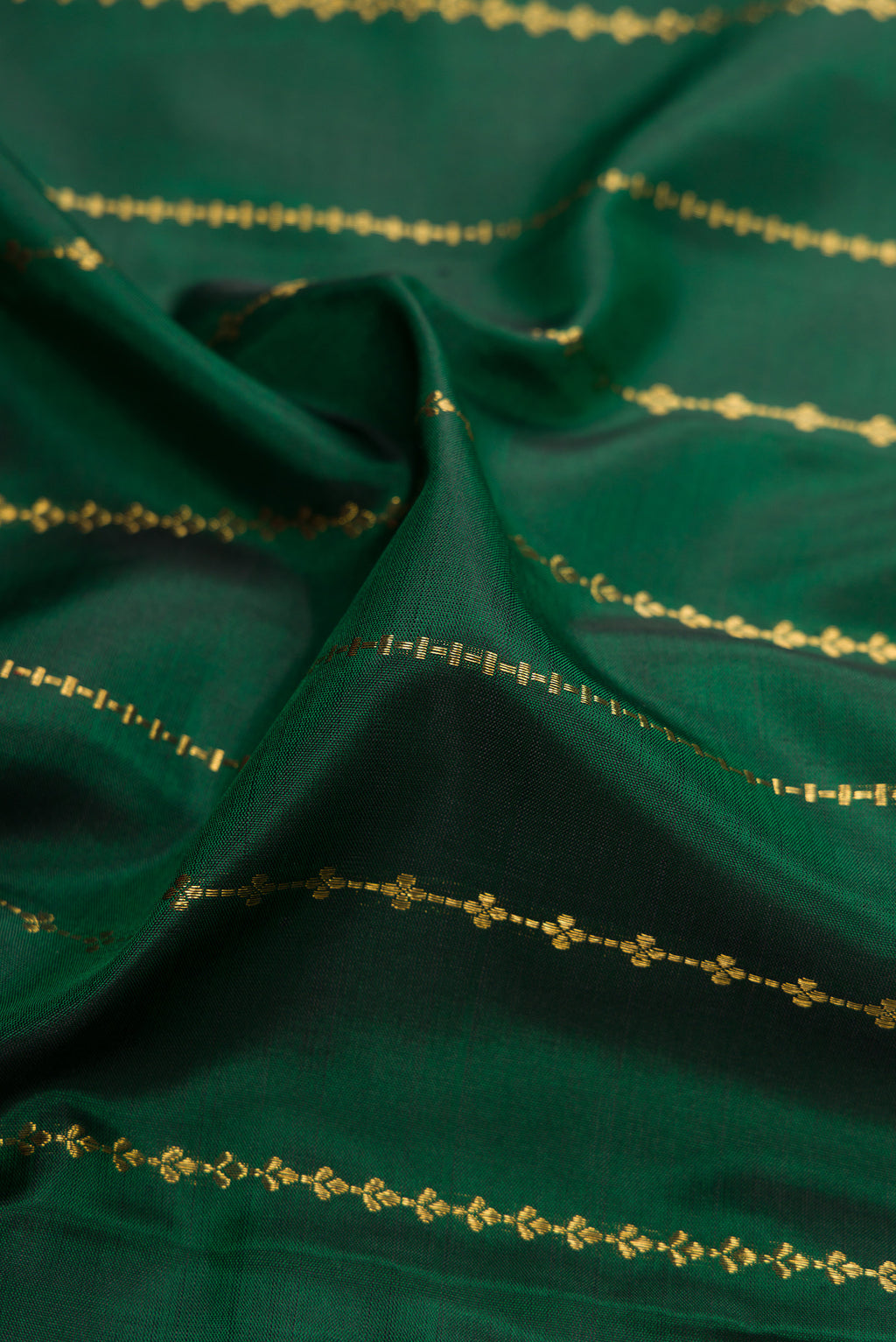 Close up of Pure Silk Pure Zari Bottle Green Kanjivaram Saree with Stripes on the body and Zari Border.  displaying folds