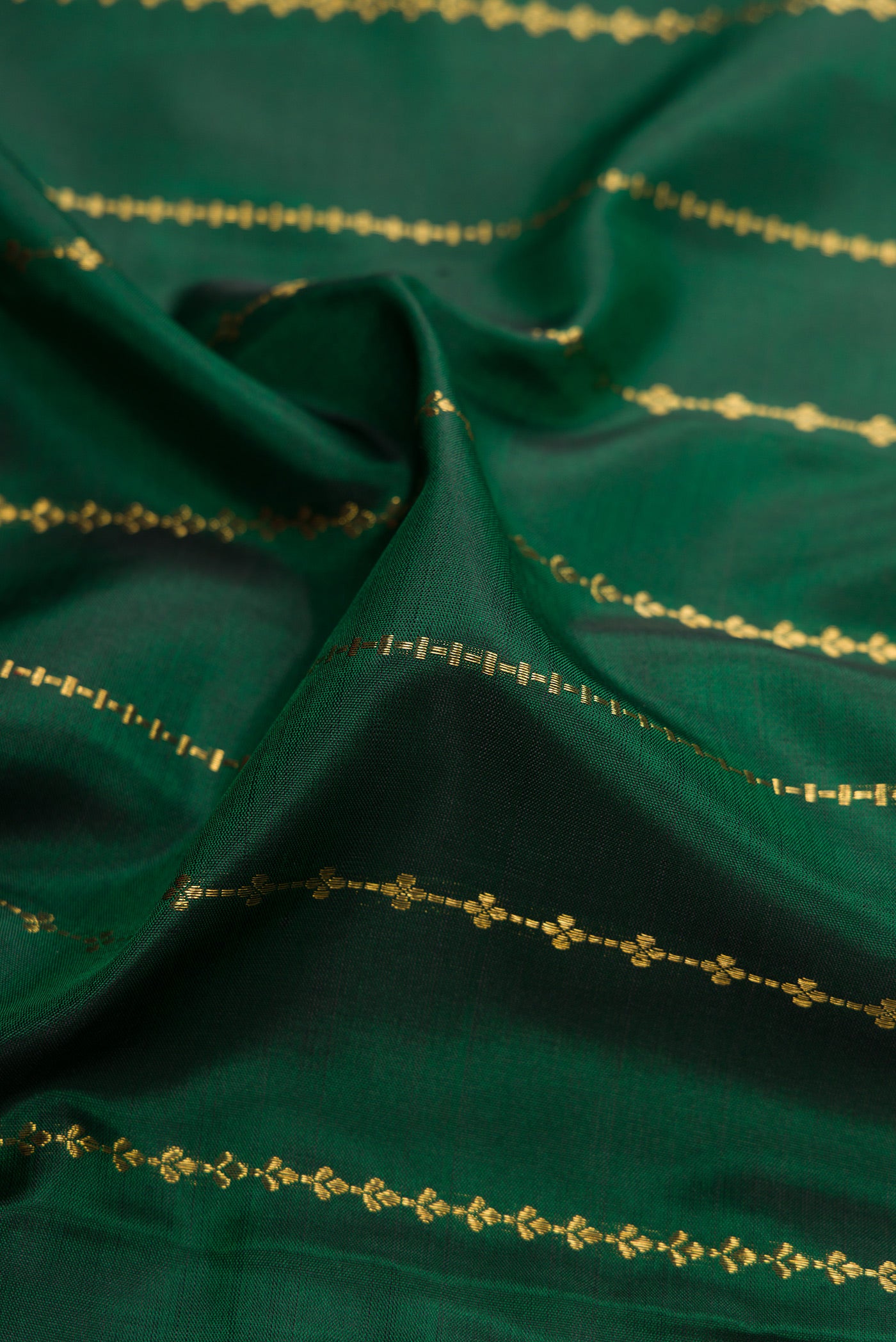 Close up of Pure Silk Pure Zari Bottle Green Kanjivaram Saree with Stripes on the body and Zari Border.  displaying folds