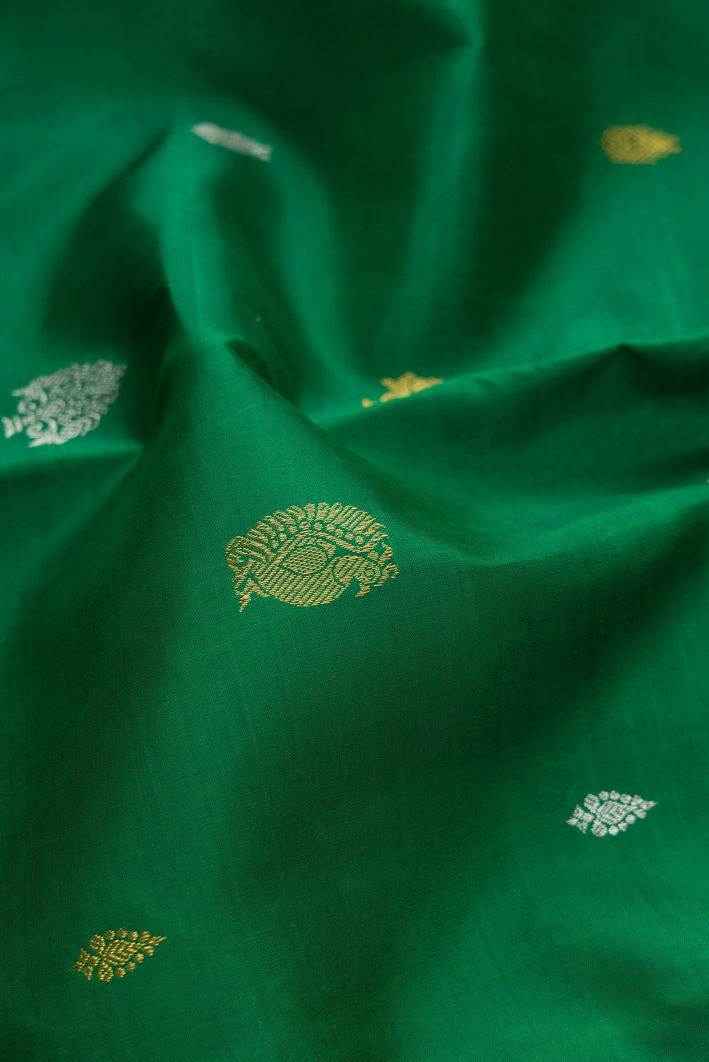 Close up of Pure Silk Pure Zari Green Dual Tone Kanchipuram Saree with Zari Butta on the body and Zari Border.  displaying folds