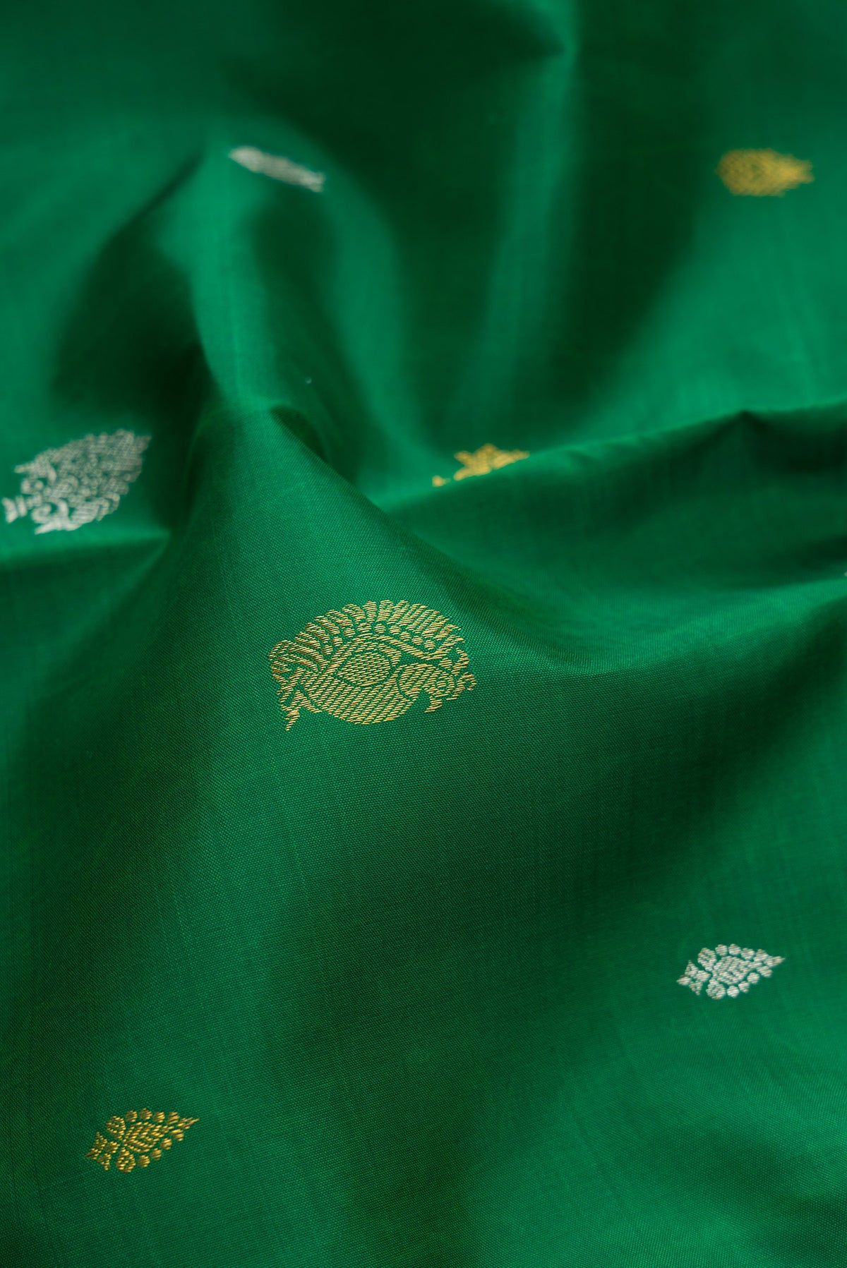 Close up of Pure Silk Pure Zari Green Dual Tone Kanchipuram Saree with Zari Butta on the body and Zari Border.  displaying folds