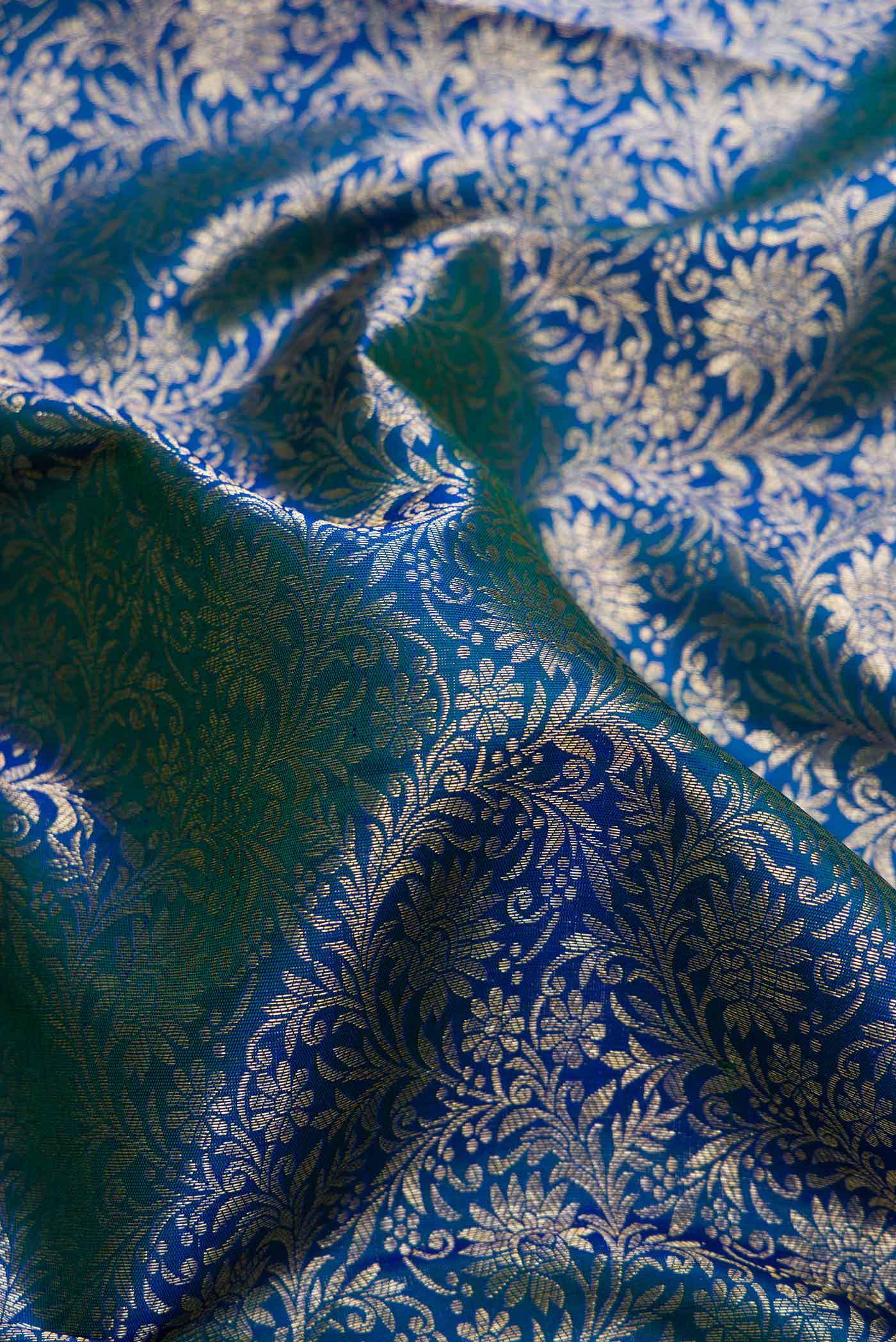 Close up of Peacock Blue Dual Tone Kanchipuram Silk Saree with Zari Brocade on the body and Zari Border.  displaying folds