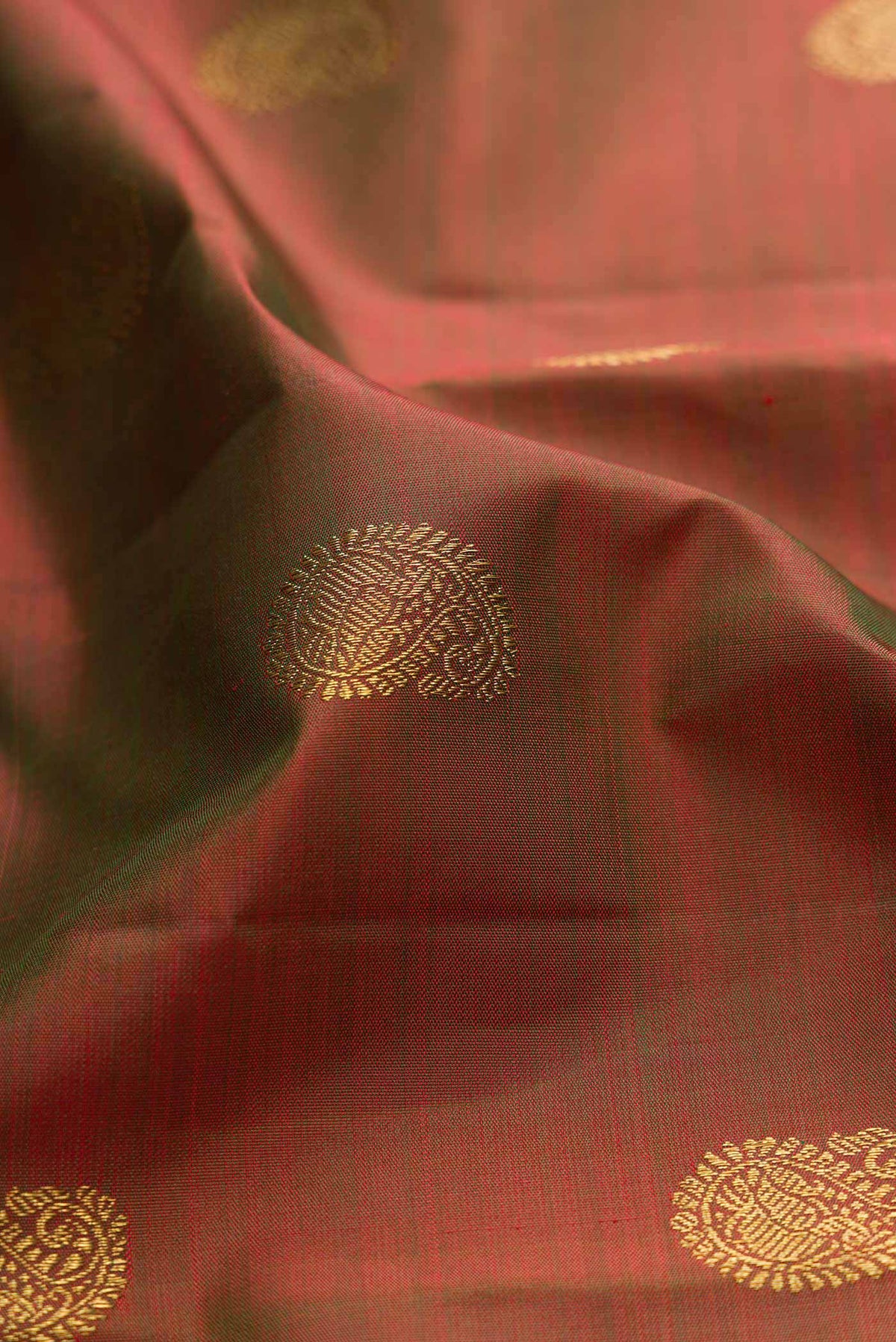 Close up of Mehandi Green Dual Tone Kanchipuram Silk Saree with Zari Butta on the body and Without Border displaying folds