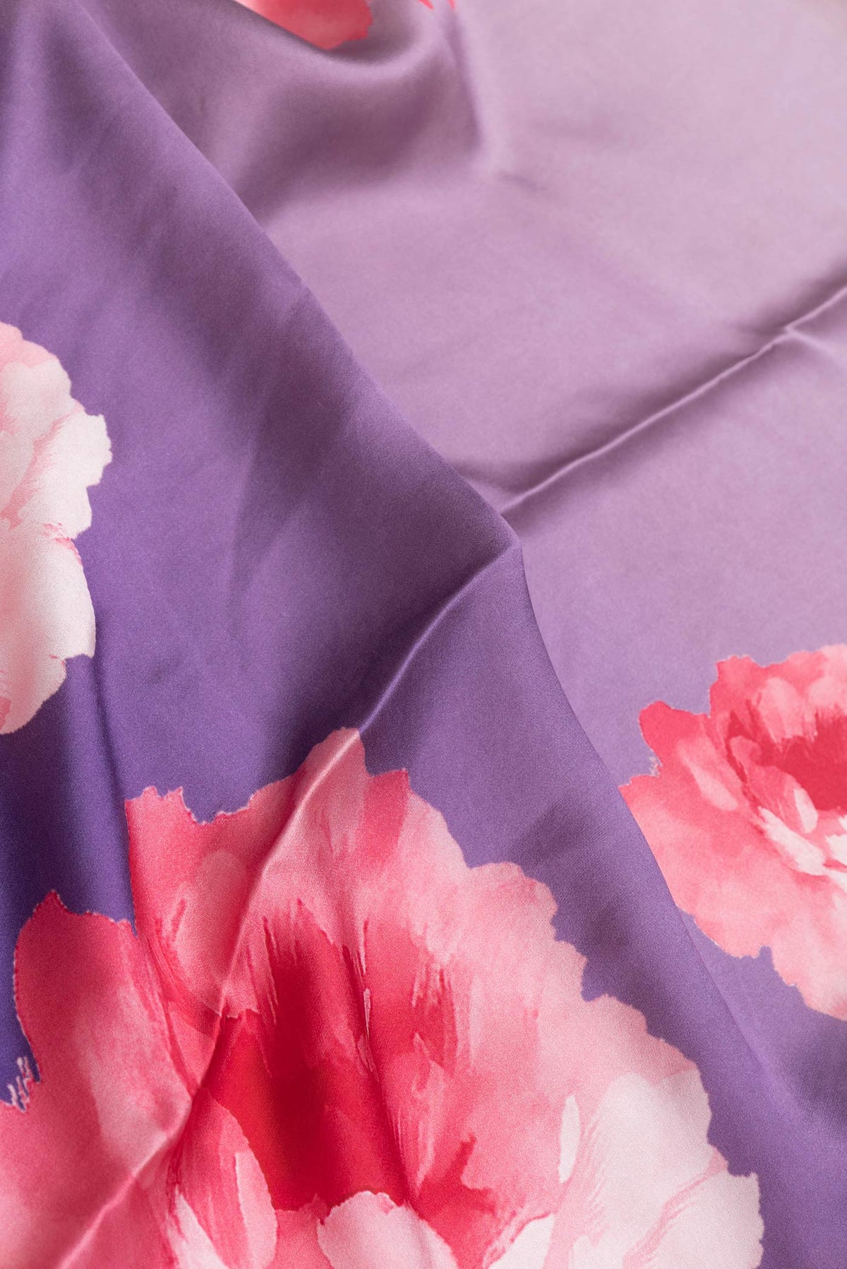 Close up of Lavender Satin Silk Saree with Floral Print on the body and Without Border displaying folds