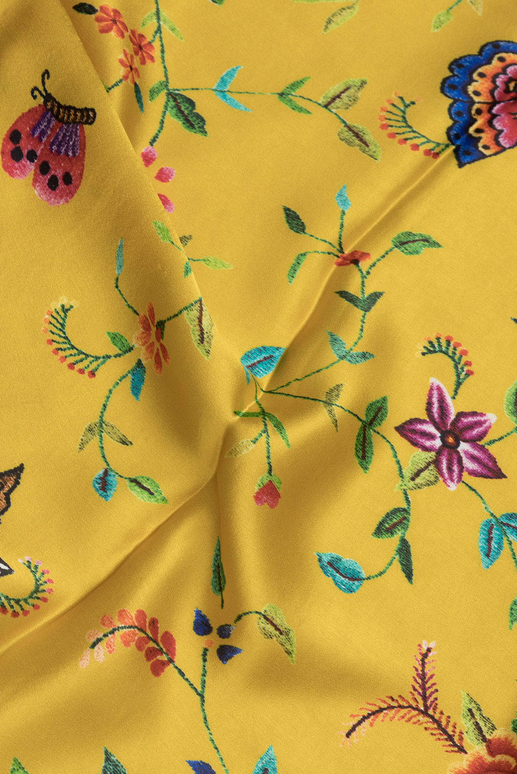 Close up of Yellow Dual Tone Crepe Saree with Printed design on the body and Printed Border.  displaying folds
