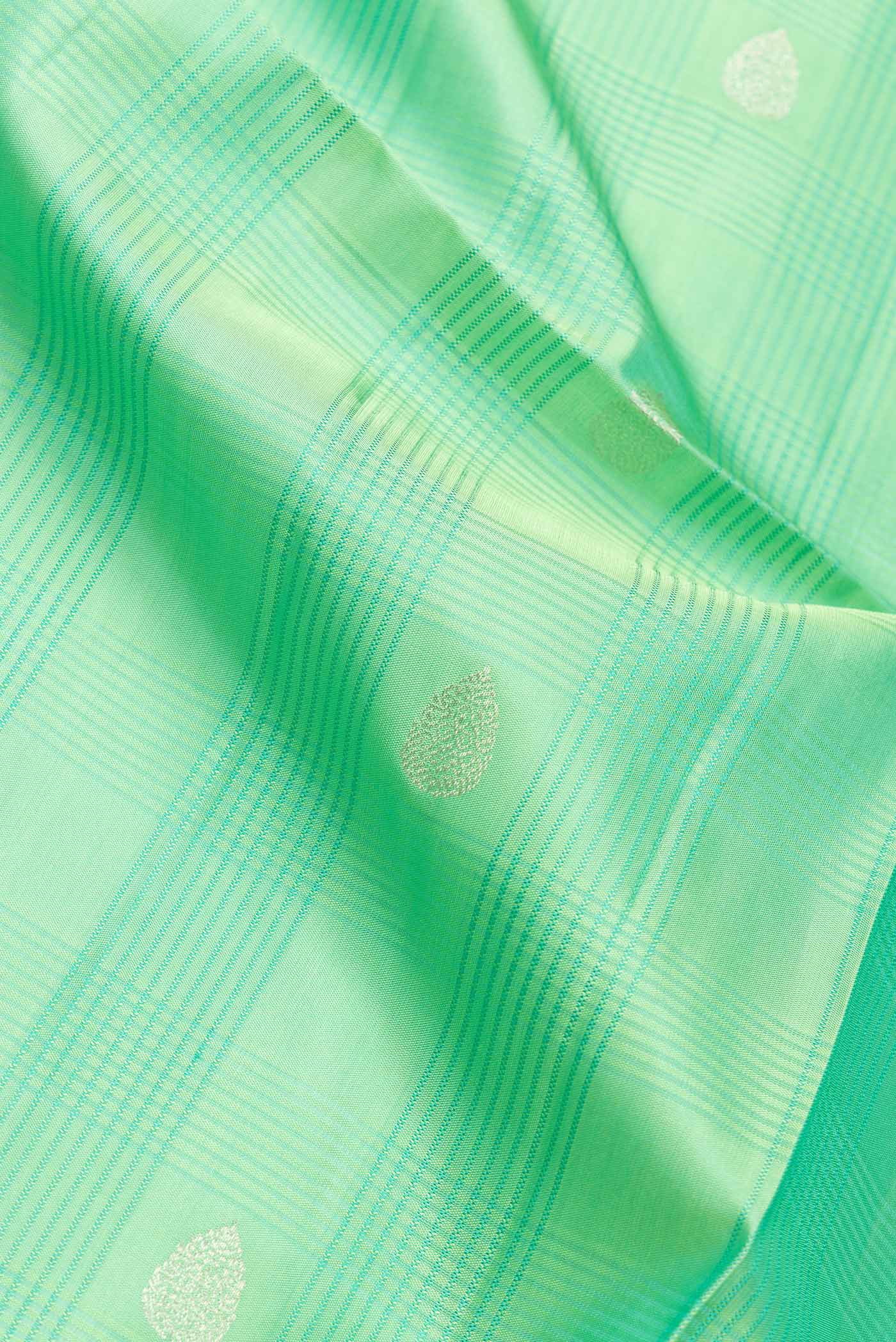 Close up of Pista Green Dual Tone Soft Silk Saree with Zari Butta on the body and Plain Border.  displaying folds