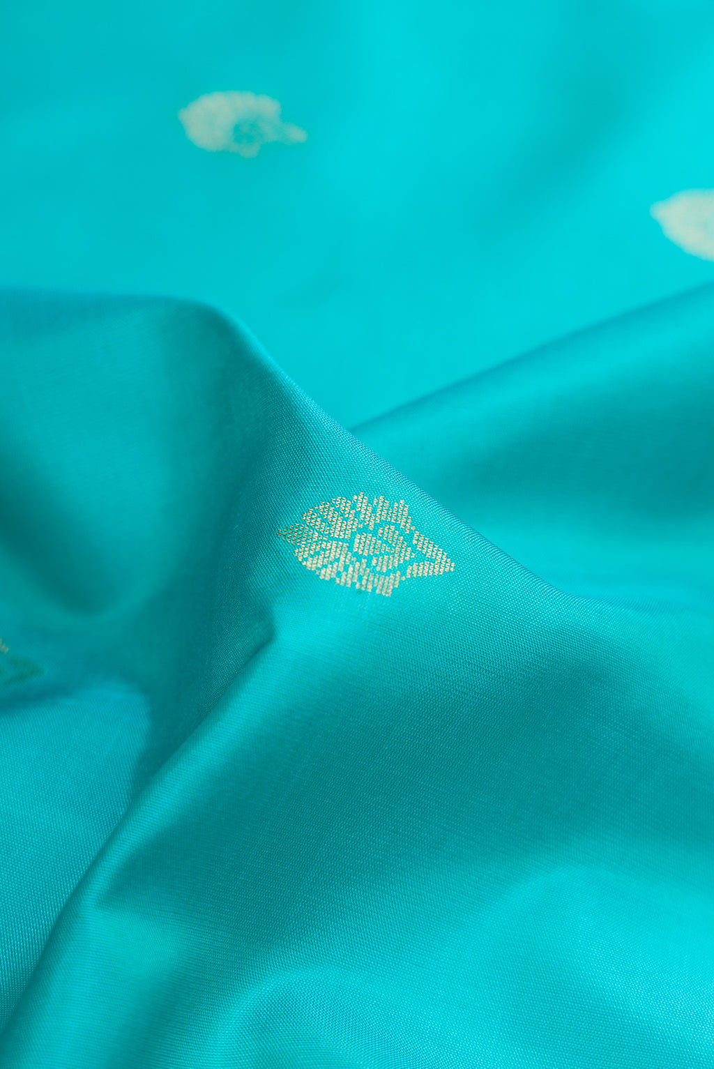 Close up of Sky Blue Dual Tone Soft Silk Saree with Zari Butta on the body and Zari Border.  displaying folds