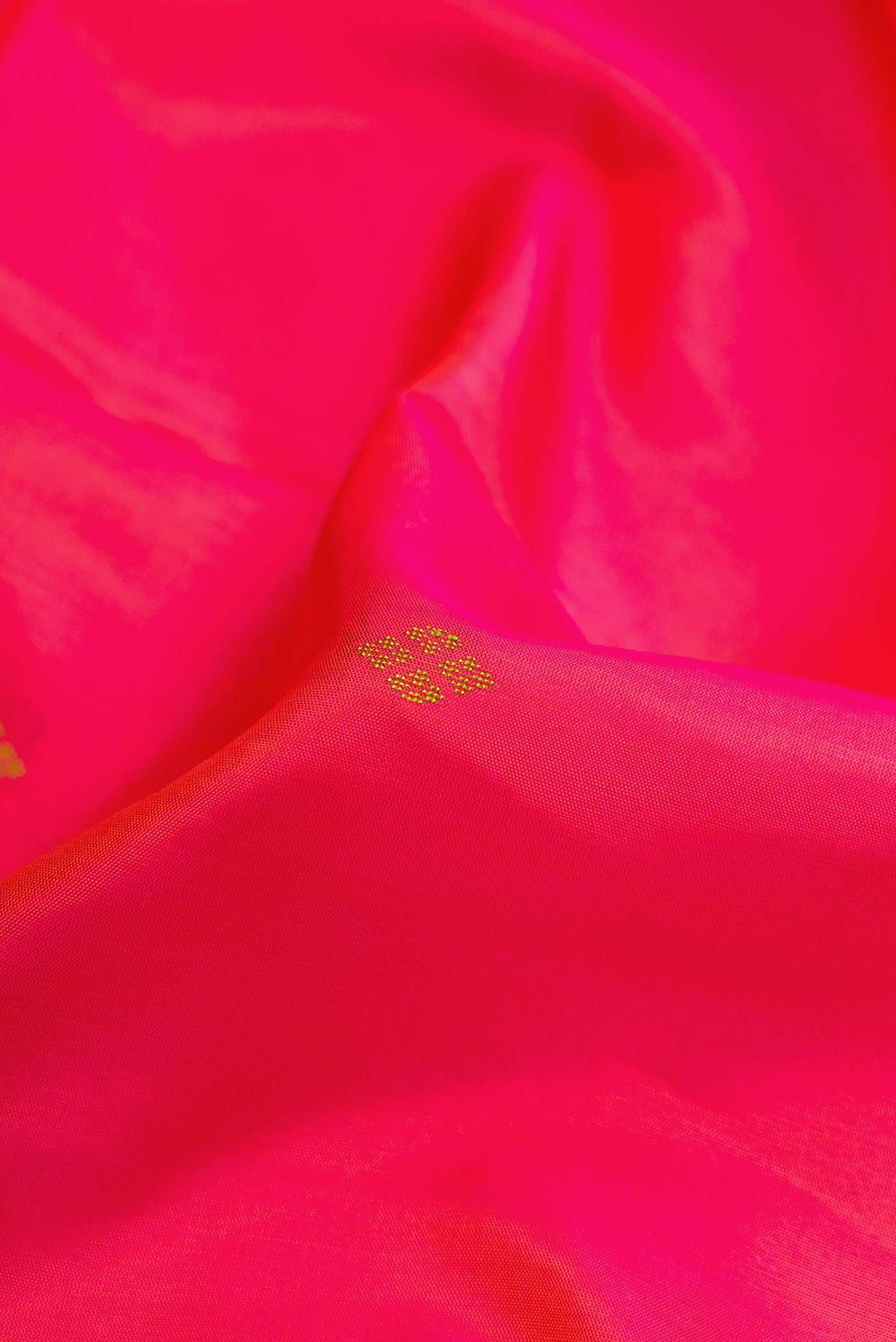 Close up of Coral Dual Tone Soft Silk Saree with Thread Butta on the body and Fancy Border.  displaying folds