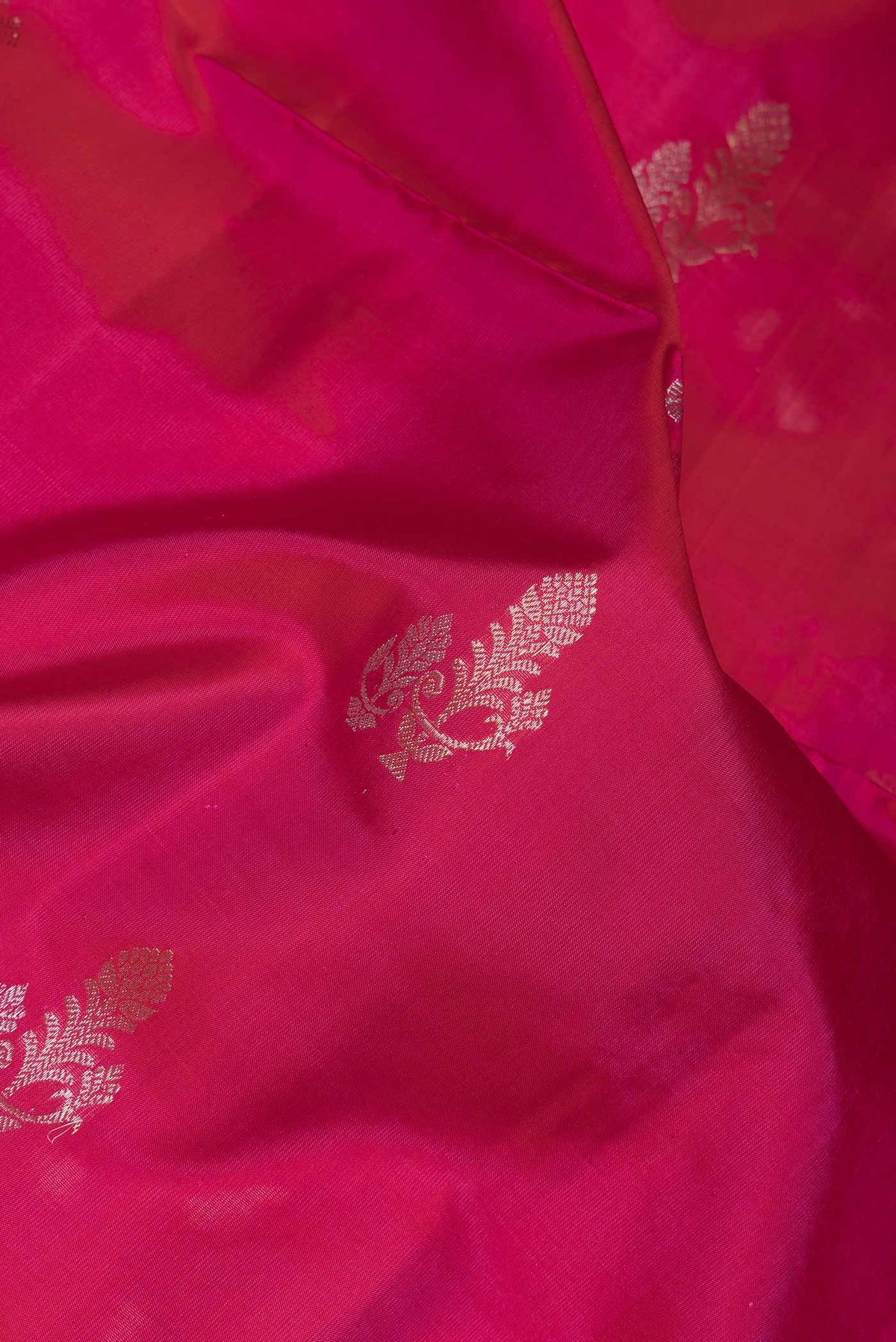 Close up of Pink Dual Tone Soft Silk Saree with Zari Butta on the body and Zari Border.  displaying folds
