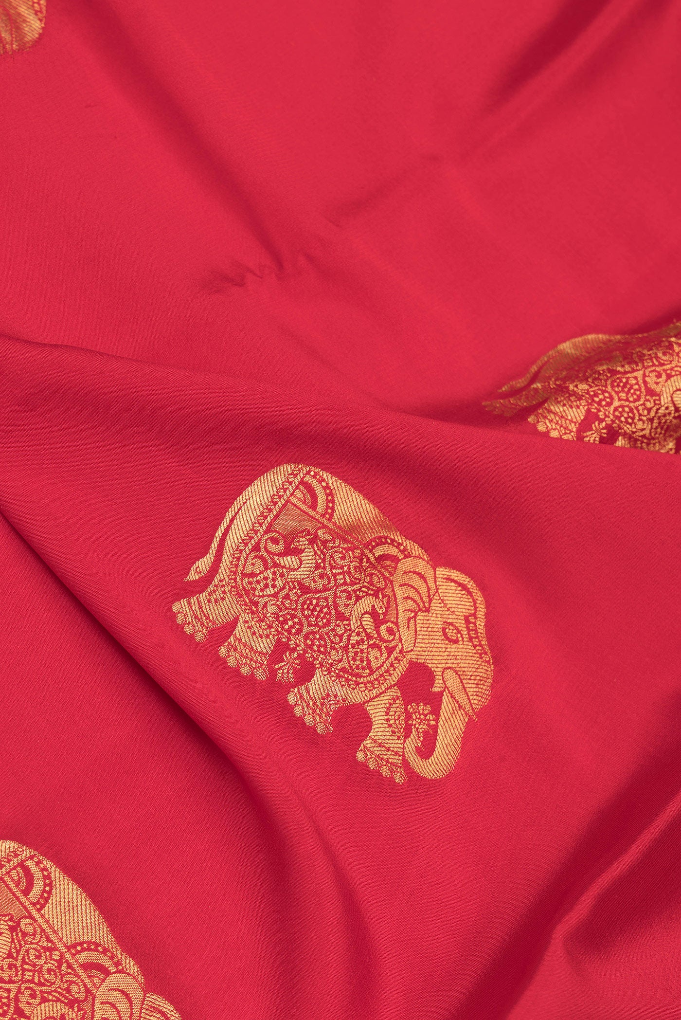 Close up of Red Dual Tone Mysore Silk Saree with Zari Butta on the body and Zari Border.  displaying folds