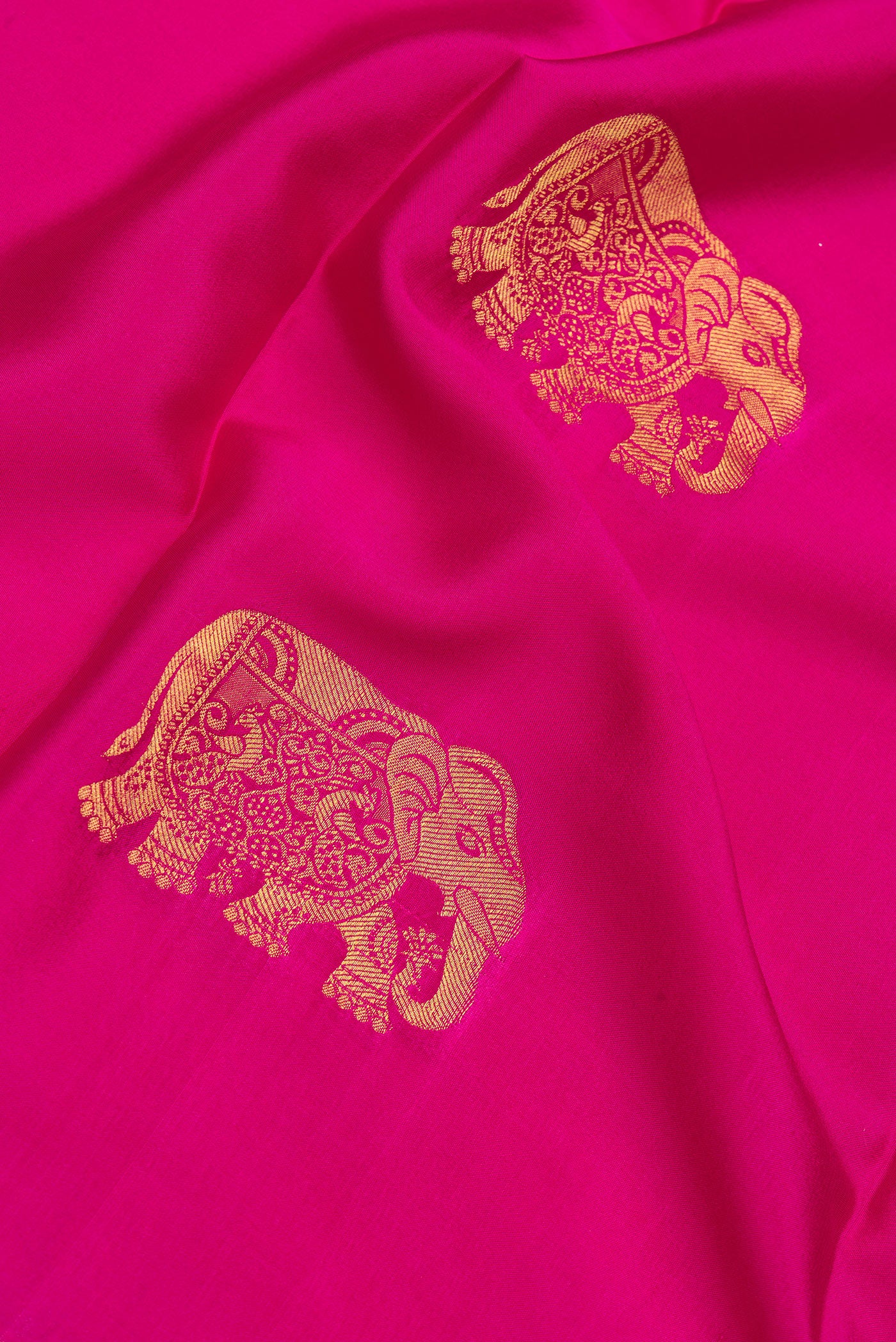 Close up of Dark Pink Mysore Silk Saree with Zari Butta on the body and Zari Border.  displaying folds