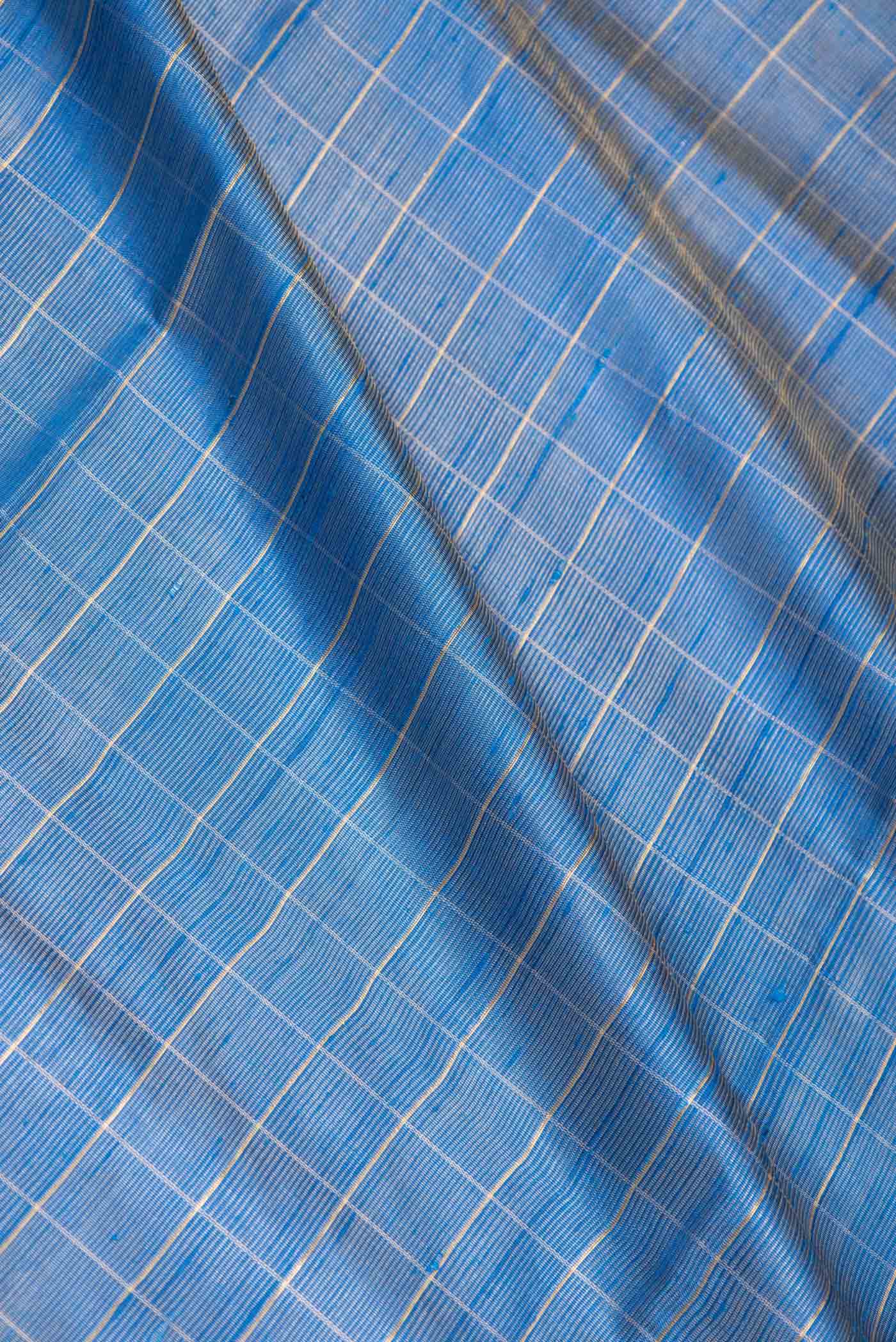 Close up of Sky Blue Dual Tone Tussar Saree with Checked design on the body and Fancy Border displaying folds