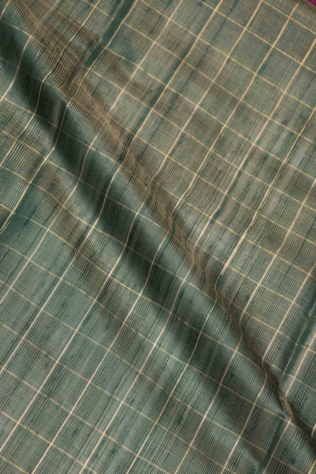 Close up of Green Dual Tone Tussar Saree with Checked design on the body and Fancy Border displaying folds