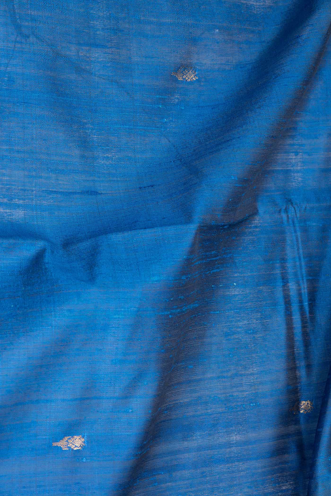 Close up of Peacock Blue Dual Tone Tussar Saree with Zari Butta on the body and Fancy Border displaying folds