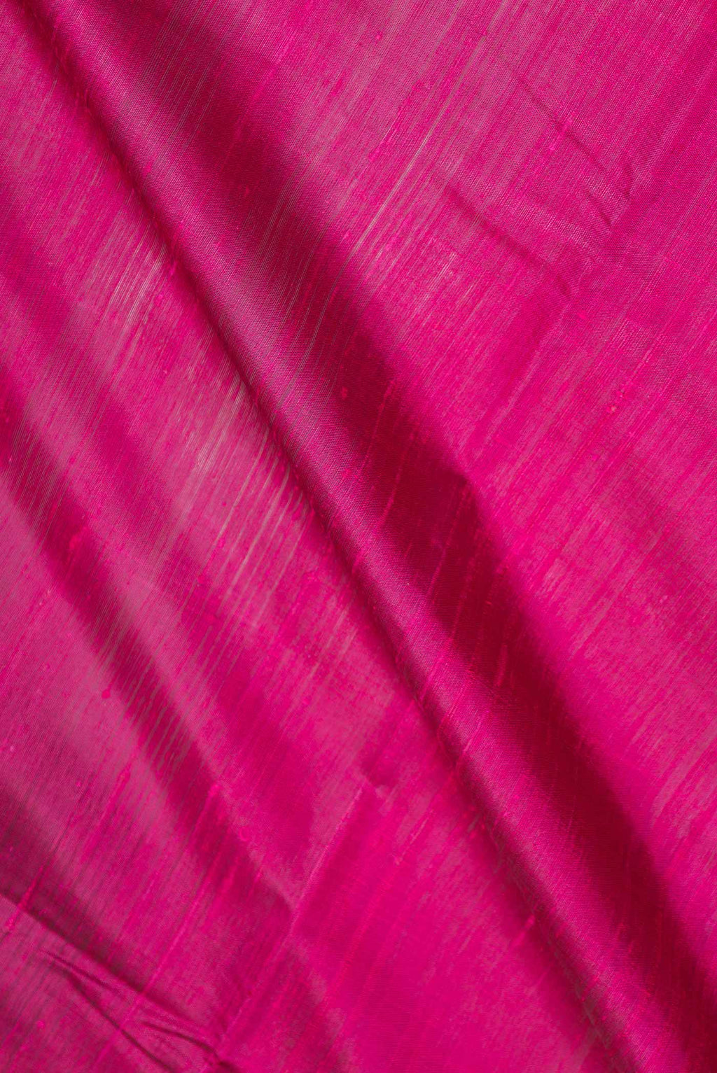 Close up of Magenta Dual Tone Tussar Saree with Plain Body and Zari Border displaying folds