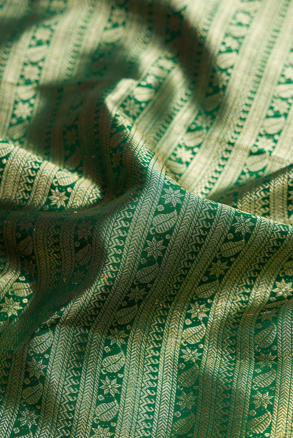 Close up of Green Dual Tone Kanchipuram Silk Saree with Zari Brocade on the body and Zari Border.  displaying folds