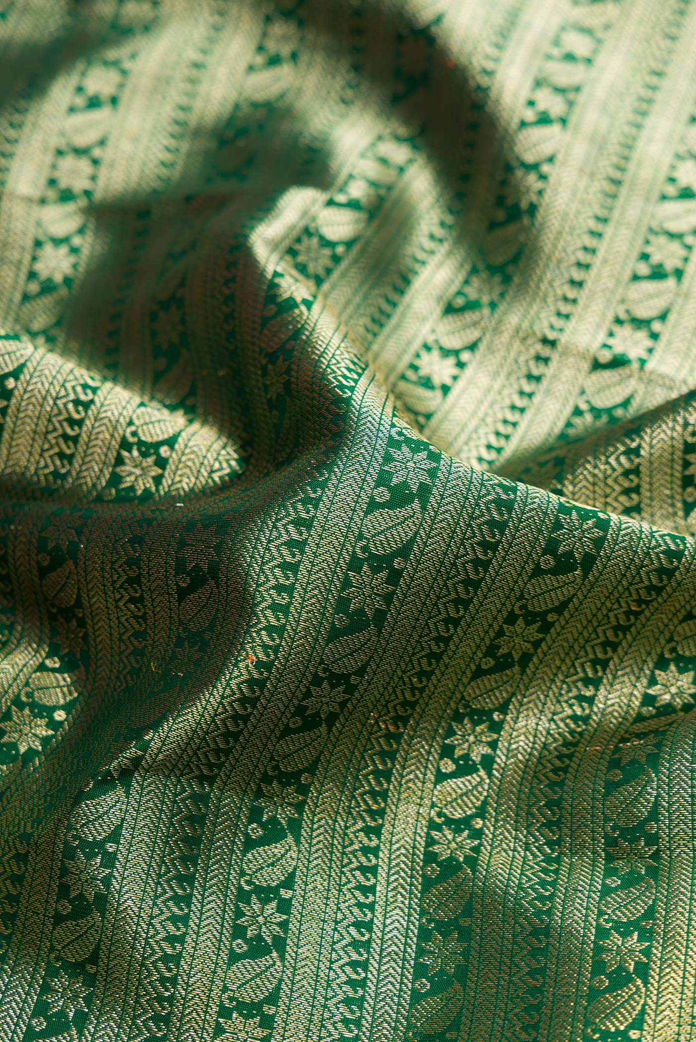 Close up of Green Dual Tone Kanchipuram Silk Saree with Zari Brocade on the body and Zari Border.  displaying folds