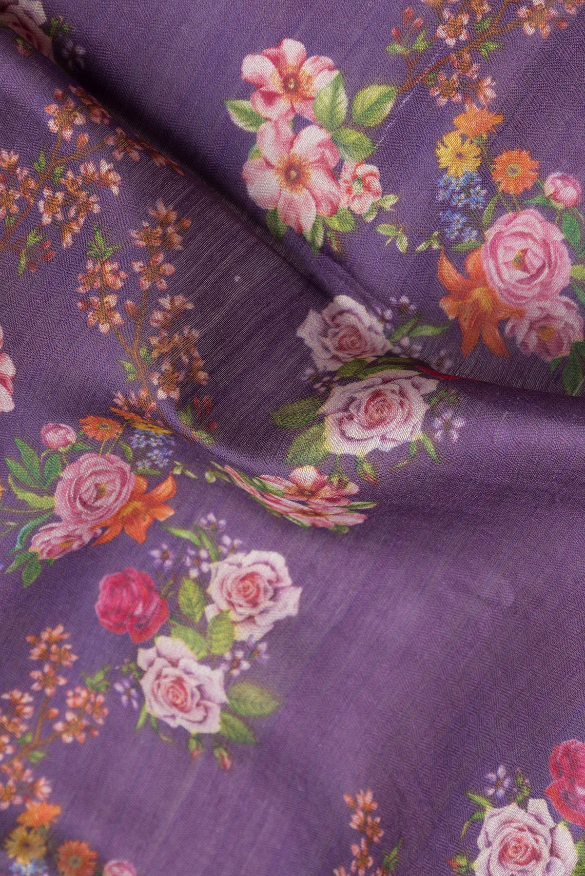 Close up of Purple Tussar Silk Saree with Floral Print on the body and Zari Border.  displaying folds