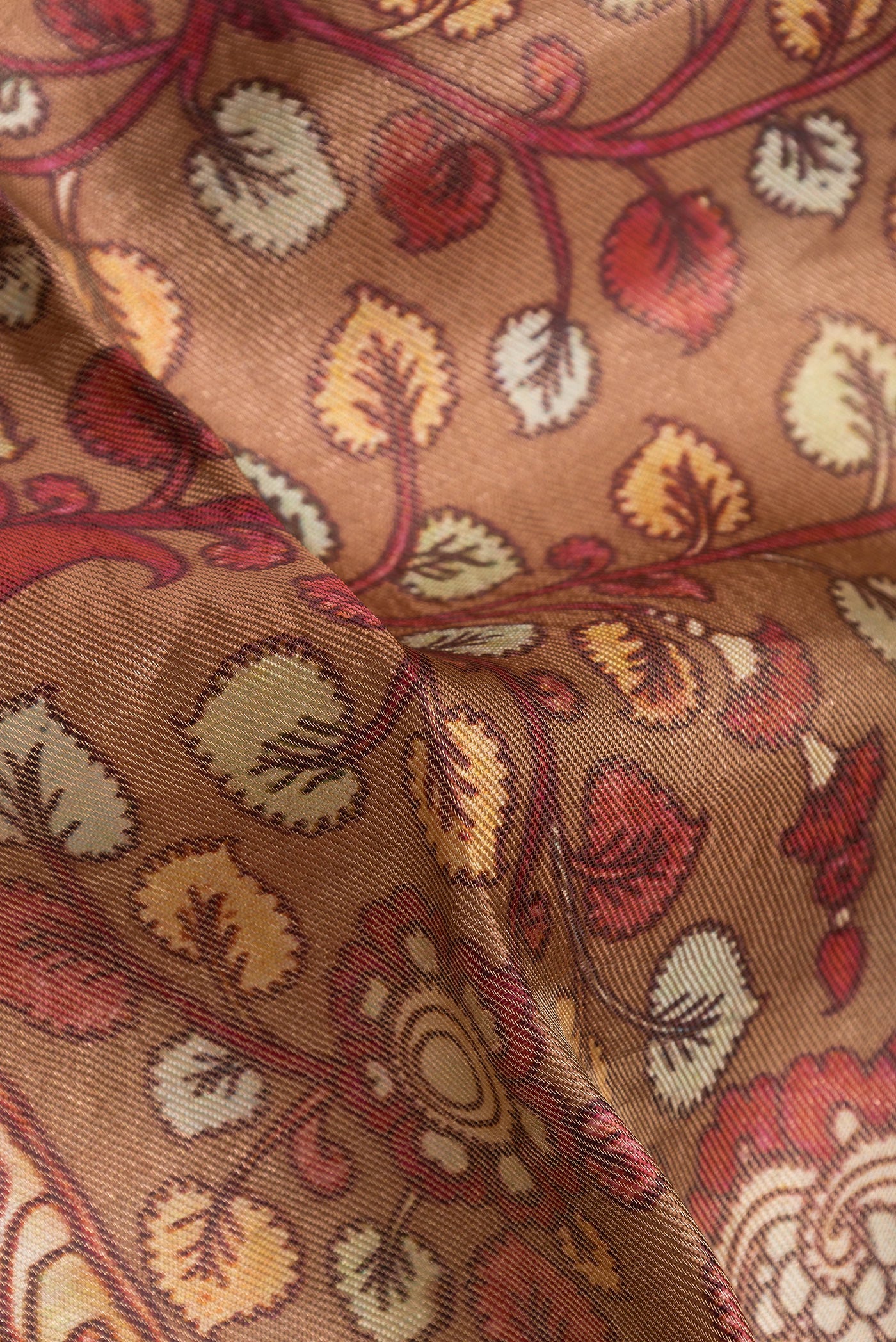 Close up of Brown Dual Tone Tussar Silk Saree with kalamkari Print on the body and Zari Border.  displaying folds