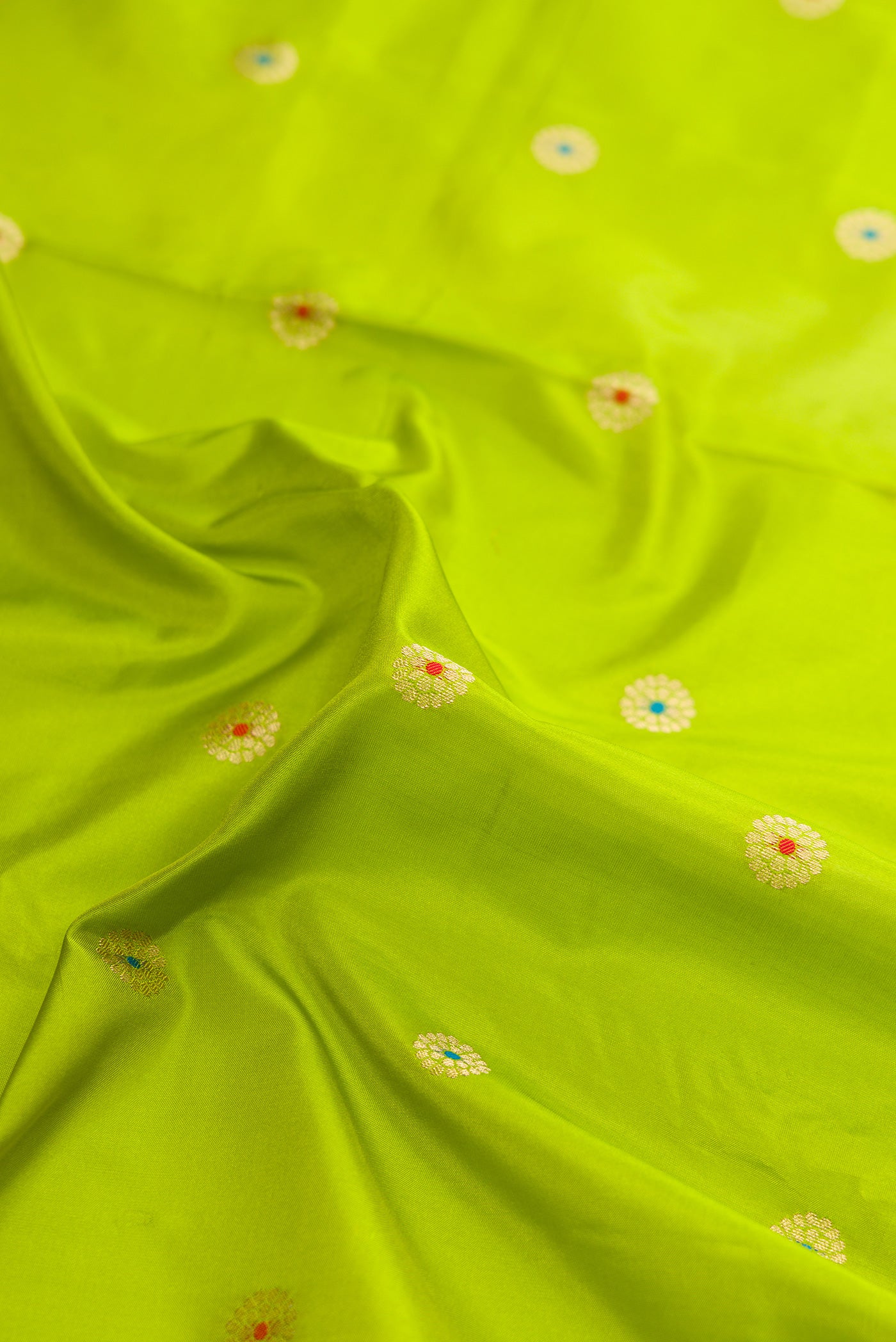 Close up of Parrot Green Dual Tone Paithani Silk Saree with Zari And Thread Butta on the body and Zari Border.  displaying folds