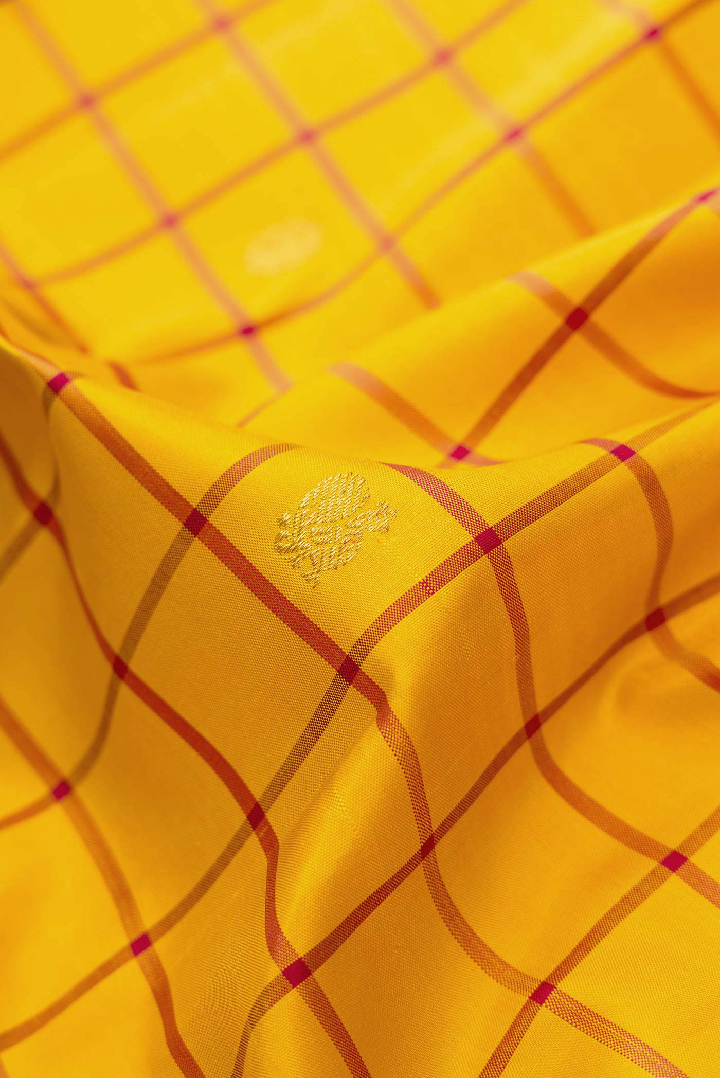 Close up of Yellow Dual Tone Kanjivaram Silk Saree with Checked design on the body and Zari Border.  displaying folds