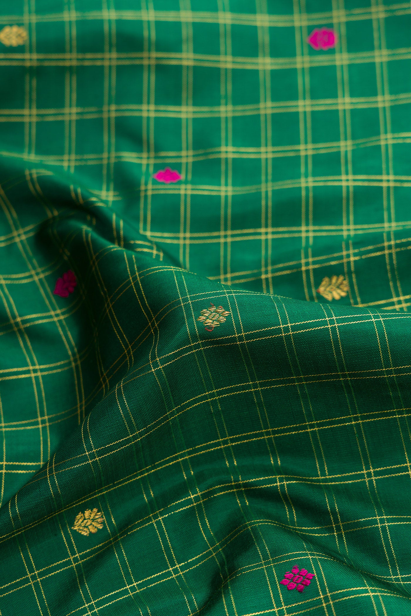Close up of Green Dual Tone Kanjivaram Silk Saree with Checked design on the body and Zari Border.  displaying folds