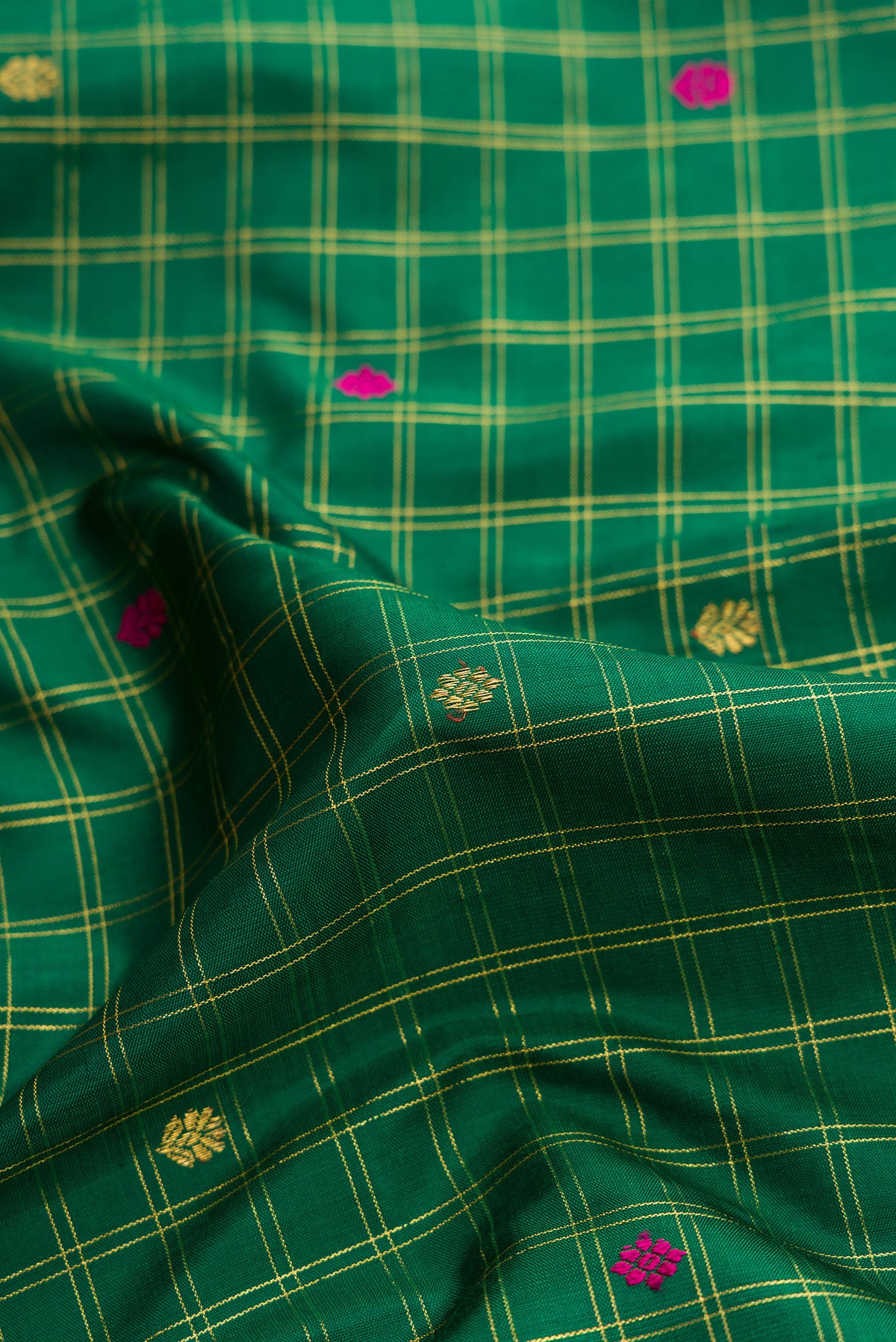 Close up of Green Dual Tone Kanjivaram Silk Saree with Checked design on the body and Zari Border.  displaying folds