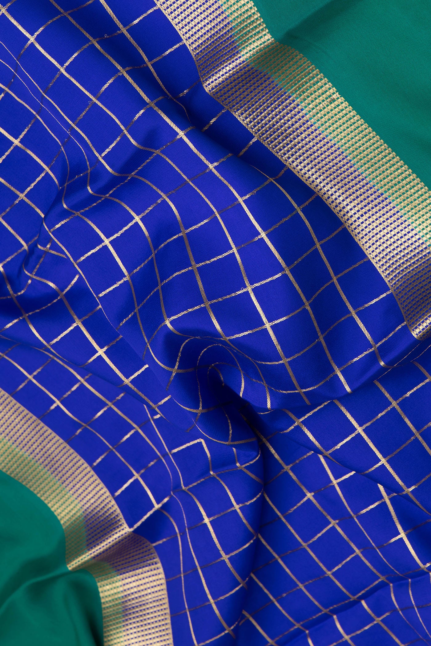 Close up of Royal Blue Mysore Silk Saree with Checked design on the body and Zari Border.  displaying folds
